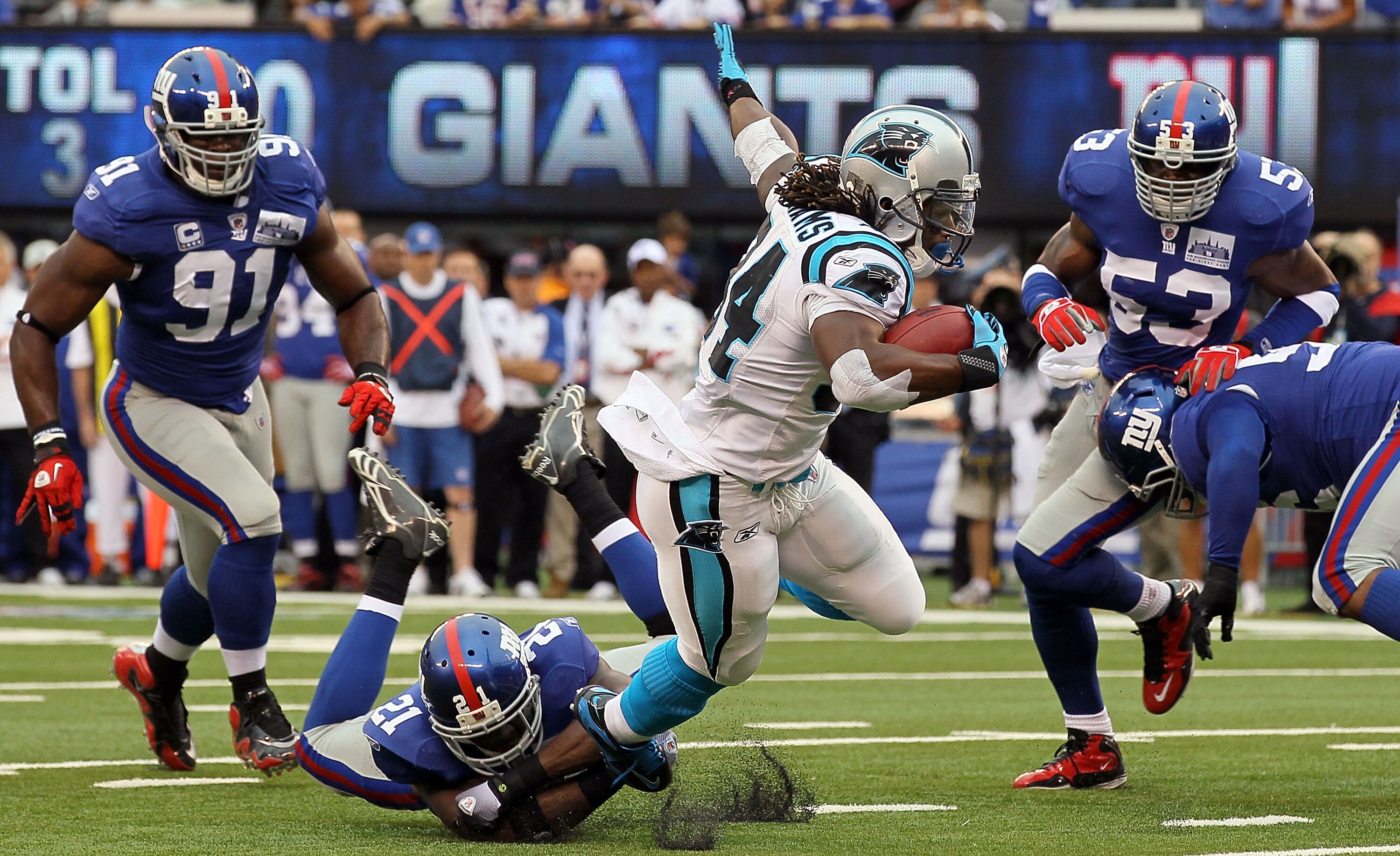EAST RUTHERFORD, NJ - SEPTEMBER 12:  DeAngelo Williams #34 of the Carolina Panthers is tackled by Kenny Phillips #21 of the New York Giants on September 12, 2010 at the New Meadowlands Stadium in East Rutherford, New Jersey.  (Photo by Jim McIsaac/Getty I