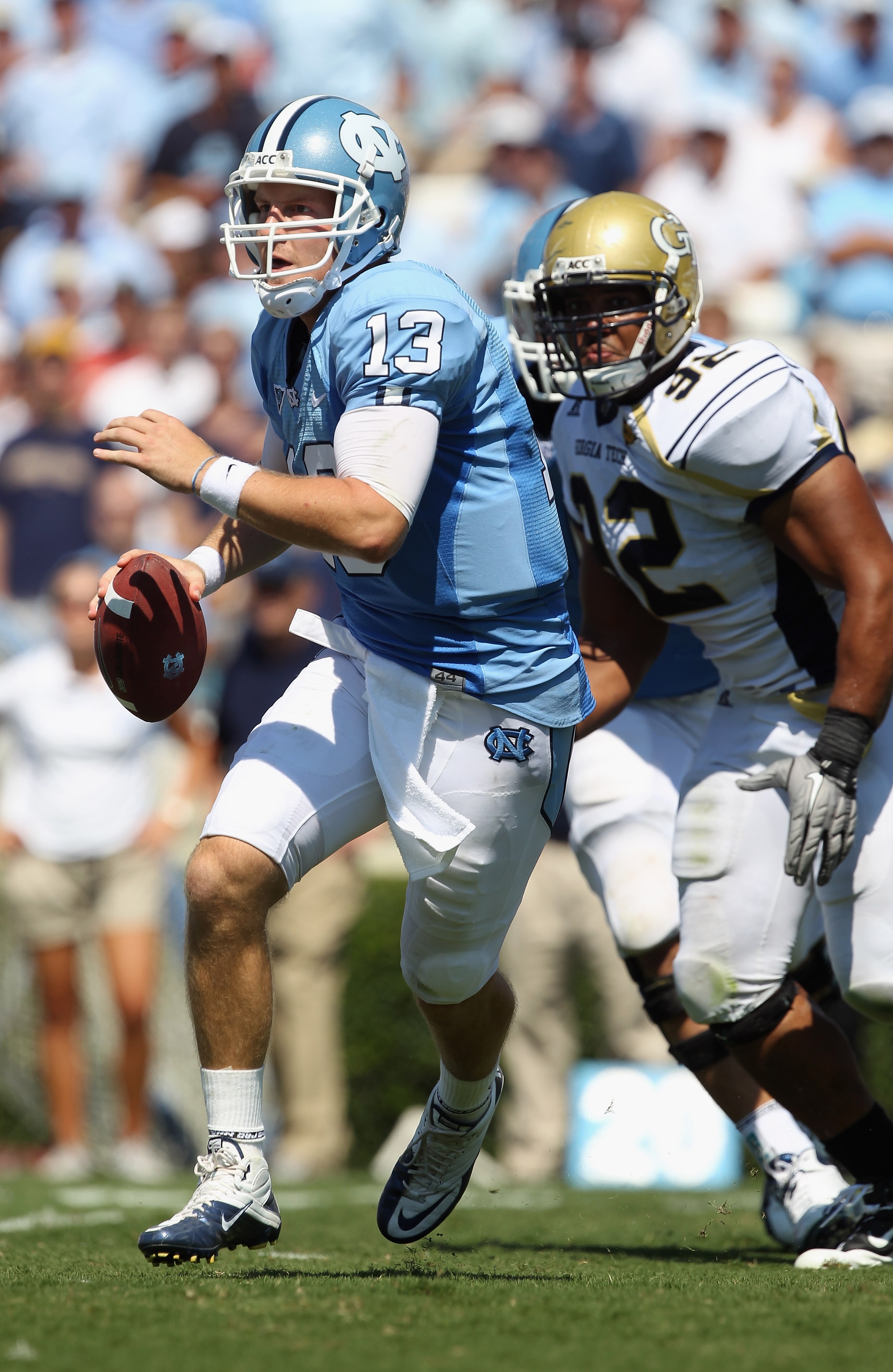 CHAPEL HILL, NC - SEPTEMBER 18:  T.J. Yates #13 of the North Carolina Tar Heels runs away from Jason Peters #92 of the Georgia Tech Yellow Jackets during their game at Kenan Stadium on September 18, 2010 in Chapel Hill, North Carolina.  (Photo by Streeter
