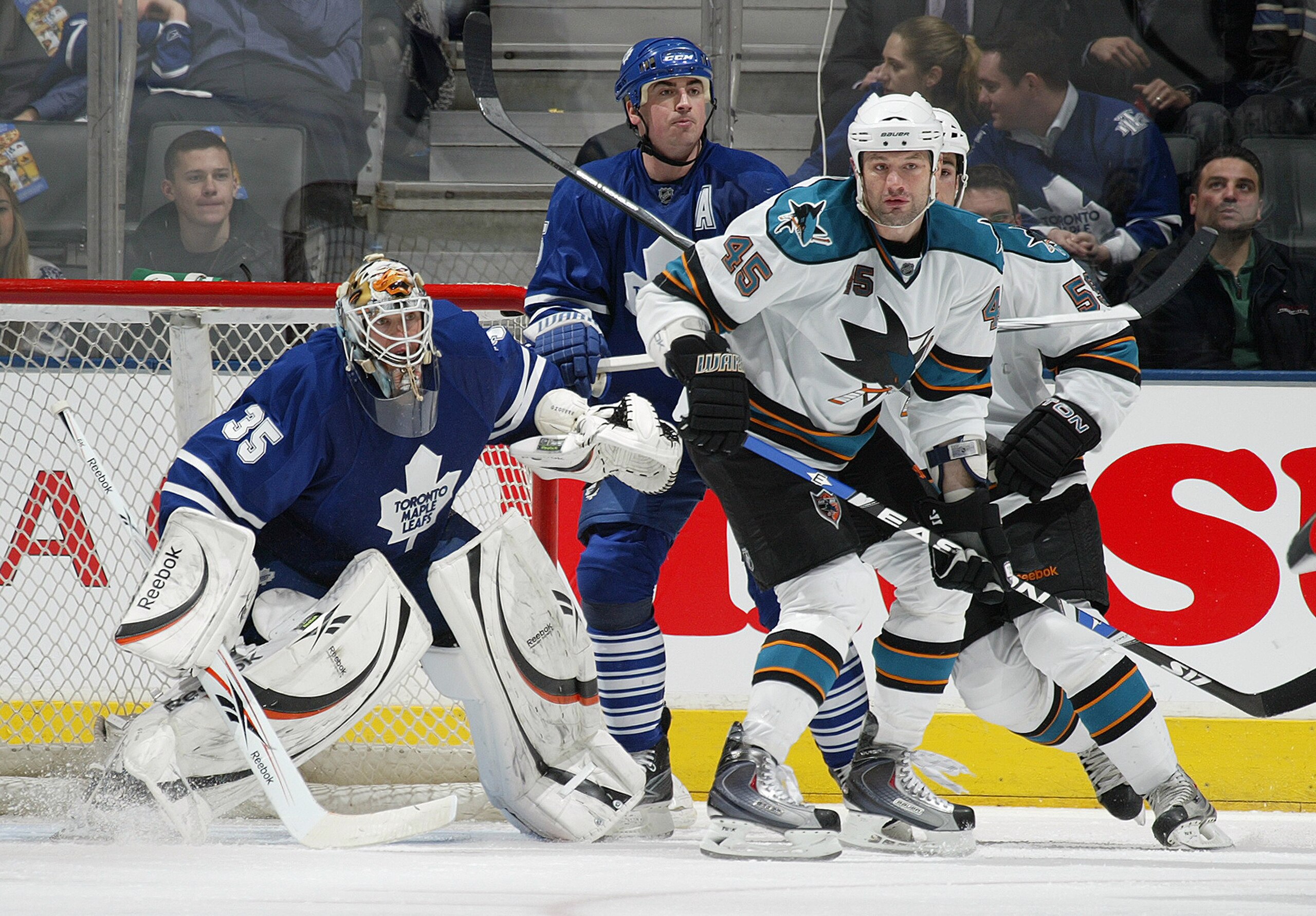 TORONTO, ON - FEBRUARY 8:  J S Giguere #35 and Tomas Kaberle #15 of the Toronto Maple Leafs try to look around Jody Shelley #45 of the San Jose Sharks in a game on February 8, 2010 at the Air Canada Centre in Toronto, Ontario. The Sharks defeated the Leaf