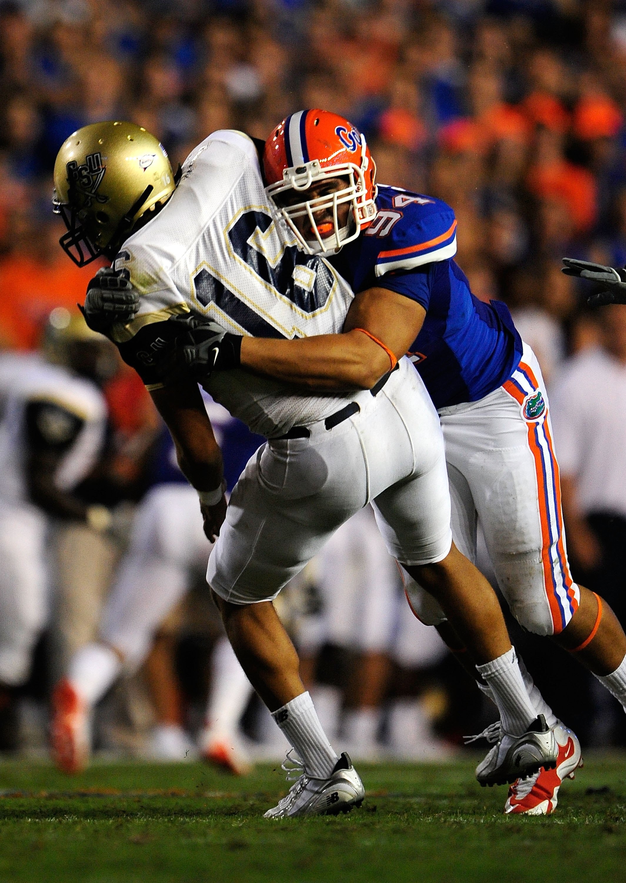 GAINESVILLE, FL - SEPTEMBER 5:  Justin Trattou #94 of the Florida Gators tackles A.J. Toscano #16 of the Charleston Southern Buccaneers during the game at Ben Hill Griffin Stadium on September 5, 2009 in Gainesville, Florida.  (Photo by Sam Greenwood/Gett