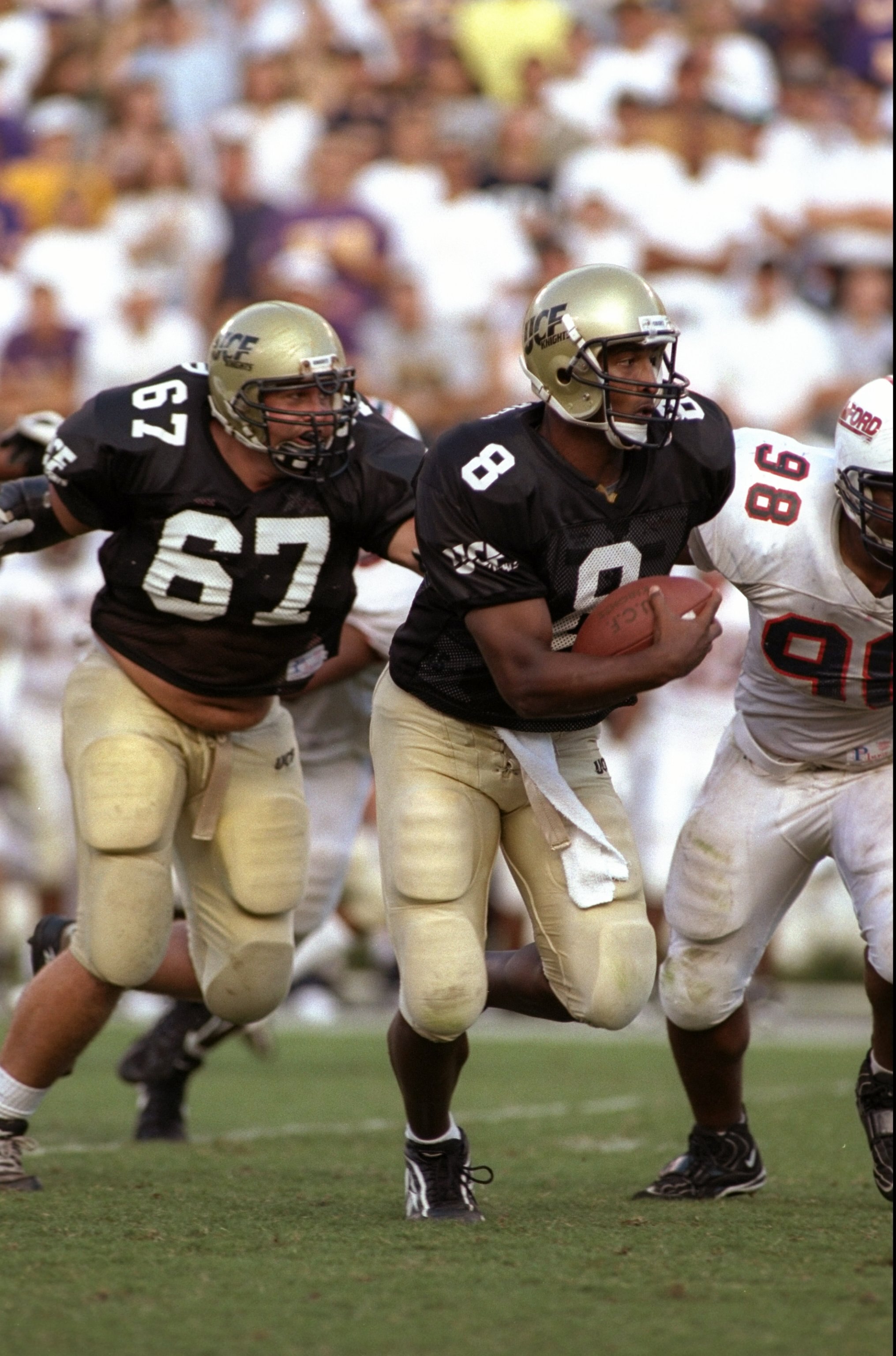 11 Oct 1997: Daunte Culpepper #8 of the Central Florida Golden Knights looks to run as teammate Ray Gould #67 guards him during the game against the Samford Bulldogs at Florida Citrus Bowl in Orlando, Florida. Central Florida defeated Samford 52-7. Mandat