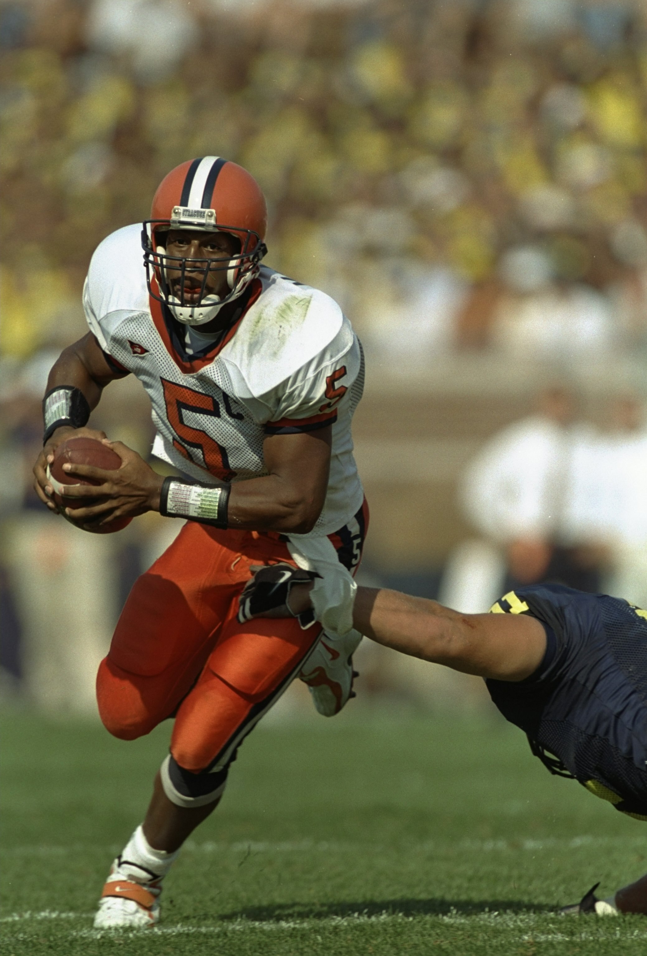 12 Sep 1998: Quarterback Donovan McNabb #5 of the Syracuse Orangeman grips the ball as he avoids being tackled during the game against Michigan Wolverines at Michigan Stadium in Ann Arbor, Michigan. Syracuse defeated Michigan 38-26.