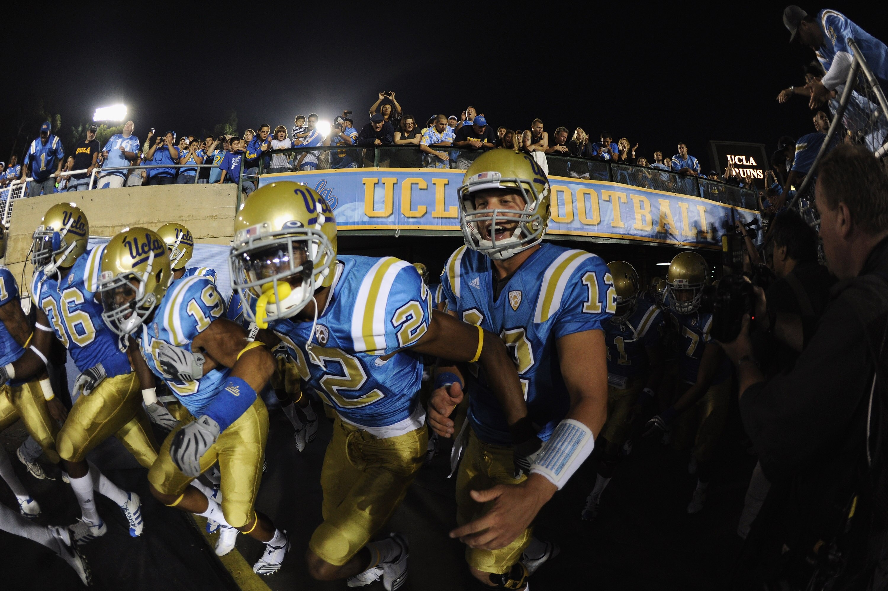 PASADENA, CA - SEPTEMBER 11:  Richard Brehaut #12, Sheldon Price #22 and Dalton Hilliard #19 of UCLA rush out to the field before the game against Stanford at the Rose Bowl on September 11, 2010 in Pasadena, California.  (Photo by Harry How/Getty Images)