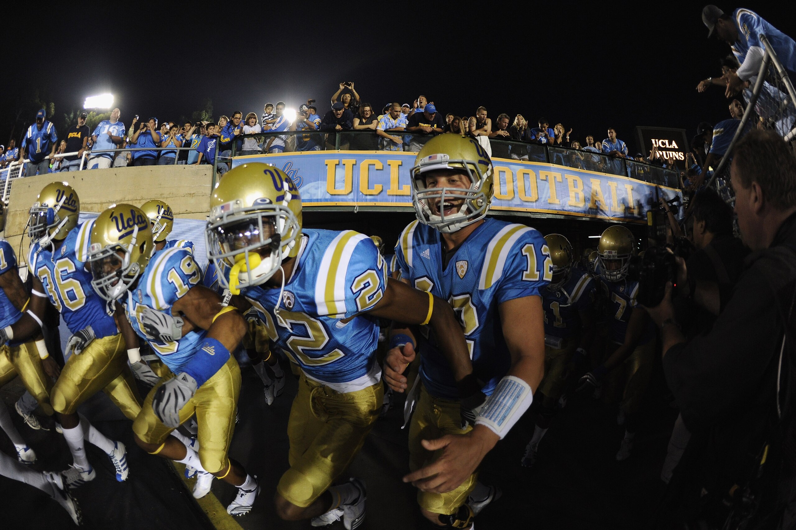 PASADENA, CA - SEPTEMBER 11:  Richard Brehaut #12, Sheldon Price #22 and Dalton Hilliard #19 of UCLA rush out to the field before the game against Stanford at the Rose Bowl on September 11, 2010 in Pasadena, California.  (Photo by Harry How/Getty Images)