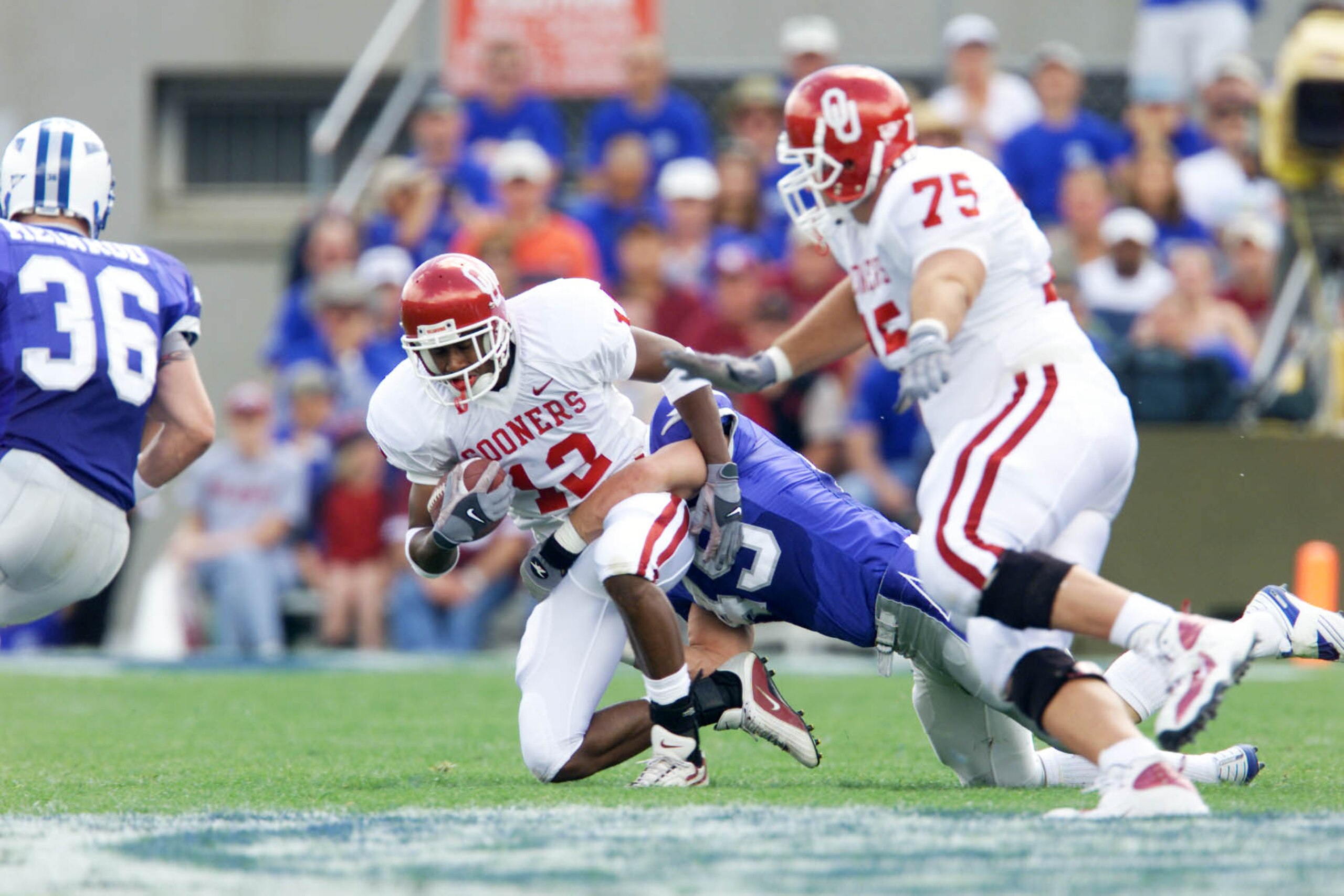 01 Sep 2001: Damian Mackey #13 of the Oklahoma Sooners is tackled by Andy Rule #49 of the Air Force Falcons during the game at Falcon Stadium in Colorado Springs, Colorado. Oklahoma won 44-3. DIGITAL IMAGE. Mandatory Credit: Brian Bahr/Allsport