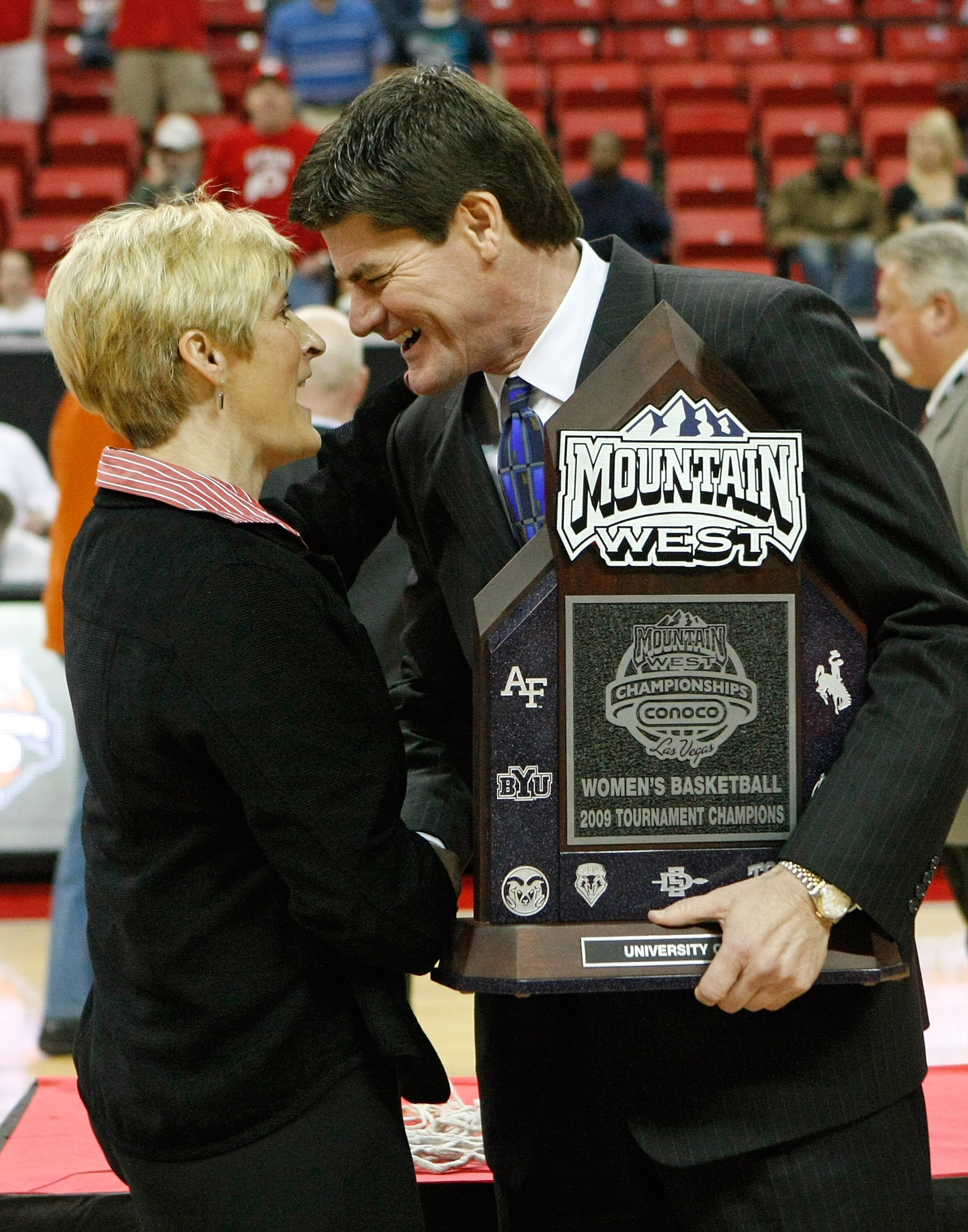 LAS VEGAS - MARCH 14:  Mountain West Conference commissioner Craig Thompson (R) presents the trophy to head coach Elaine Elliott of the Utah Utes after they defeated the San Diego State Aztecs 63-58 during the championship game of the Conoco Mountain West
