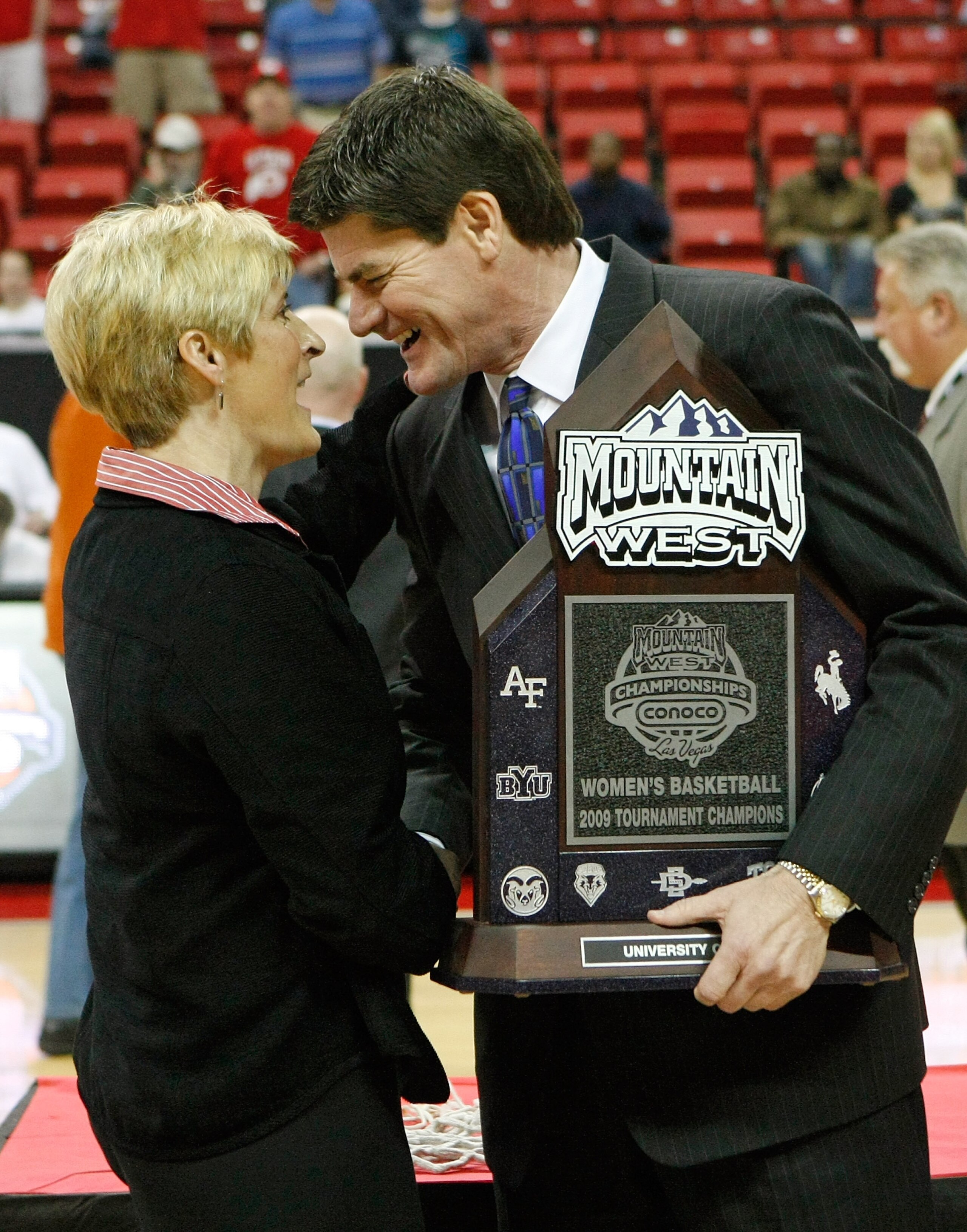 LAS VEGAS - MARCH 14:  Mountain West Conference commissioner Craig Thompson (R) presents the trophy to head coach Elaine Elliott of the Utah Utes after they defeated the San Diego State Aztecs 63-58 during the championship game of the Conoco Mountain West