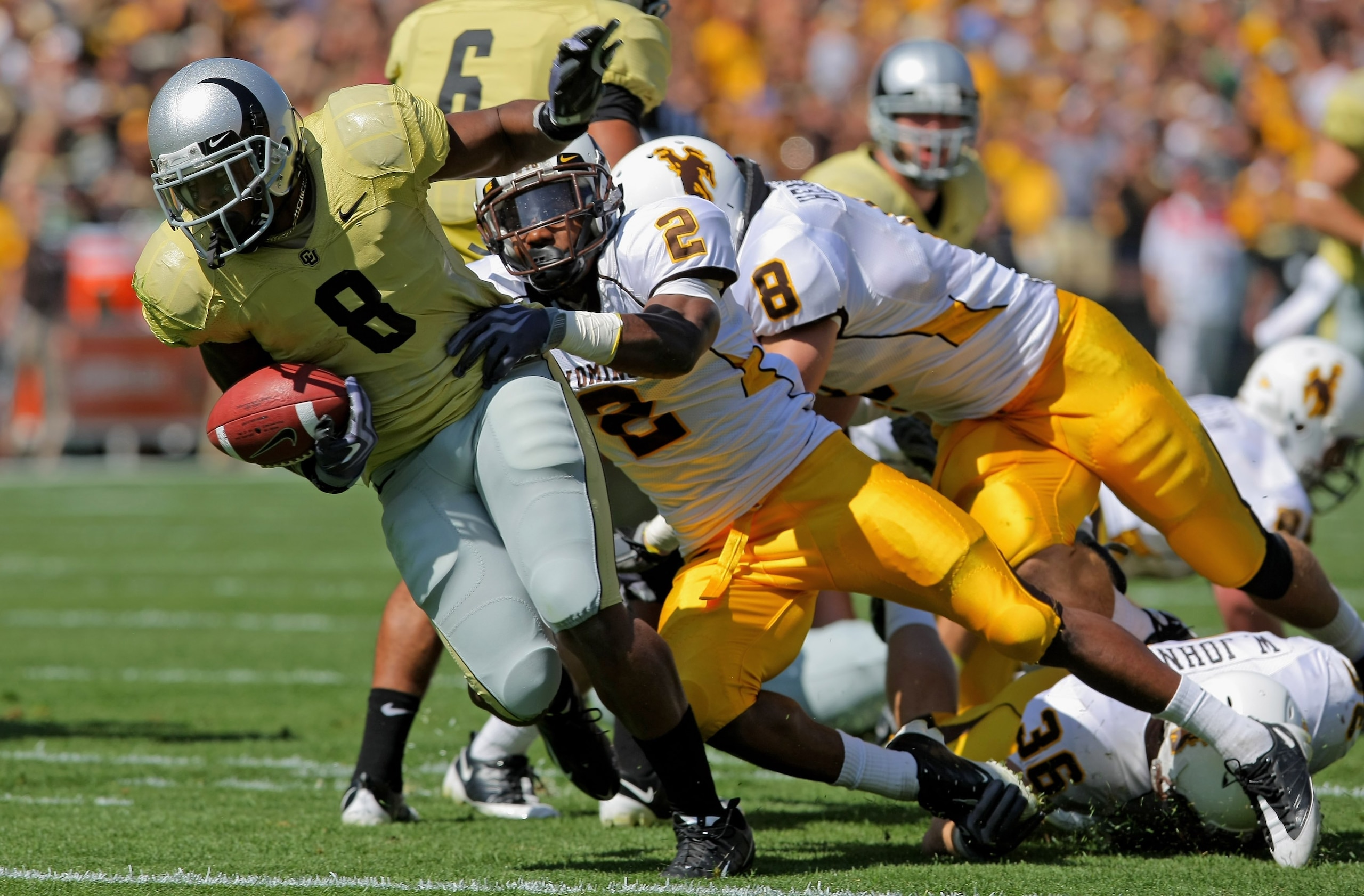 BOULDER, CO - SEPTEMBER 19:  Tailback Demetrius Sumler #8 of the Colorado Buffaloes fumbles the ball after it was knocked away by Marcell Gipson #2 of the Wyoming Cowboys which was recovered by teammate Scotty McKnight to score a first quarter touchdown a
