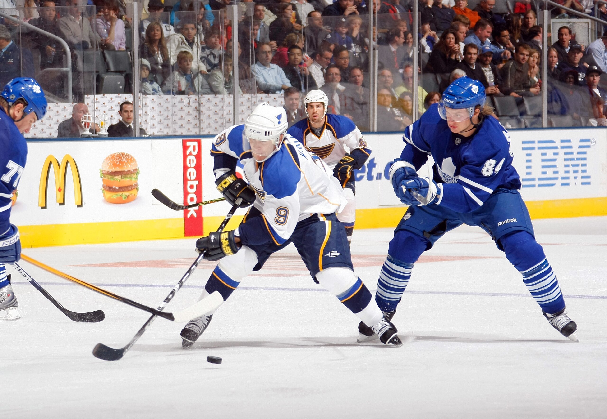 TORONTO - SEPTEMBER 29:  Paul Kariya #9 of the St. Louis Blues plays the puck in the middle slot against Mikhail Grabovski #84 of the Toronto Maple Leafs during their NHL preseason game at the Air Canada Centre on September 29, 2008 in Toronto, Ontario, C