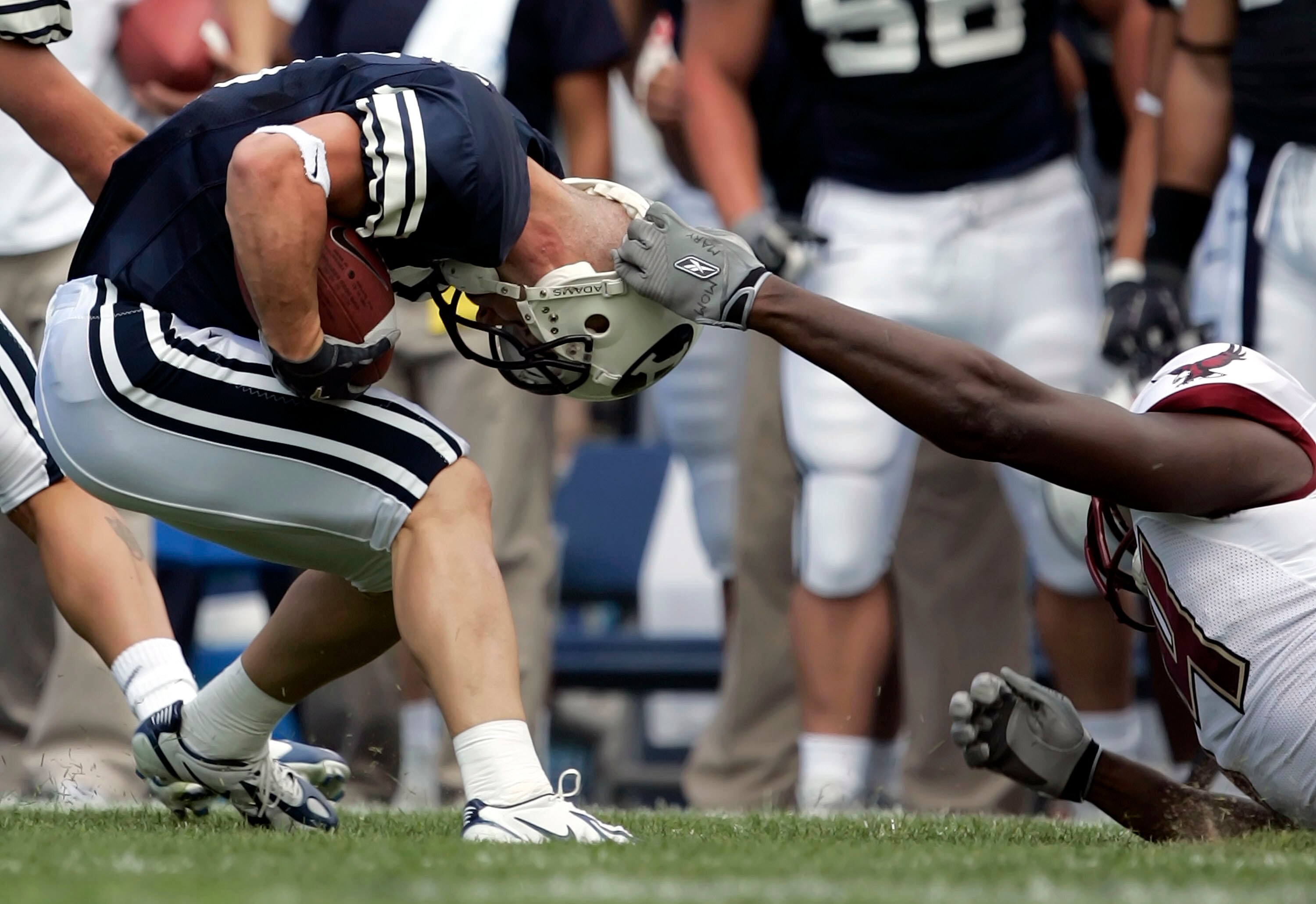 PROVO, UT - SEPTEMBER 3:  Defensive end Mathias Kiwanuka #94 of the Boston College Eagles tackles wide receiver Nathan Meikle #31 of the Brigham Young Cougars by the helmet on September 3, 2005 at LaVell Edwards Stadium in Provo, Utah.  (Photo by George F