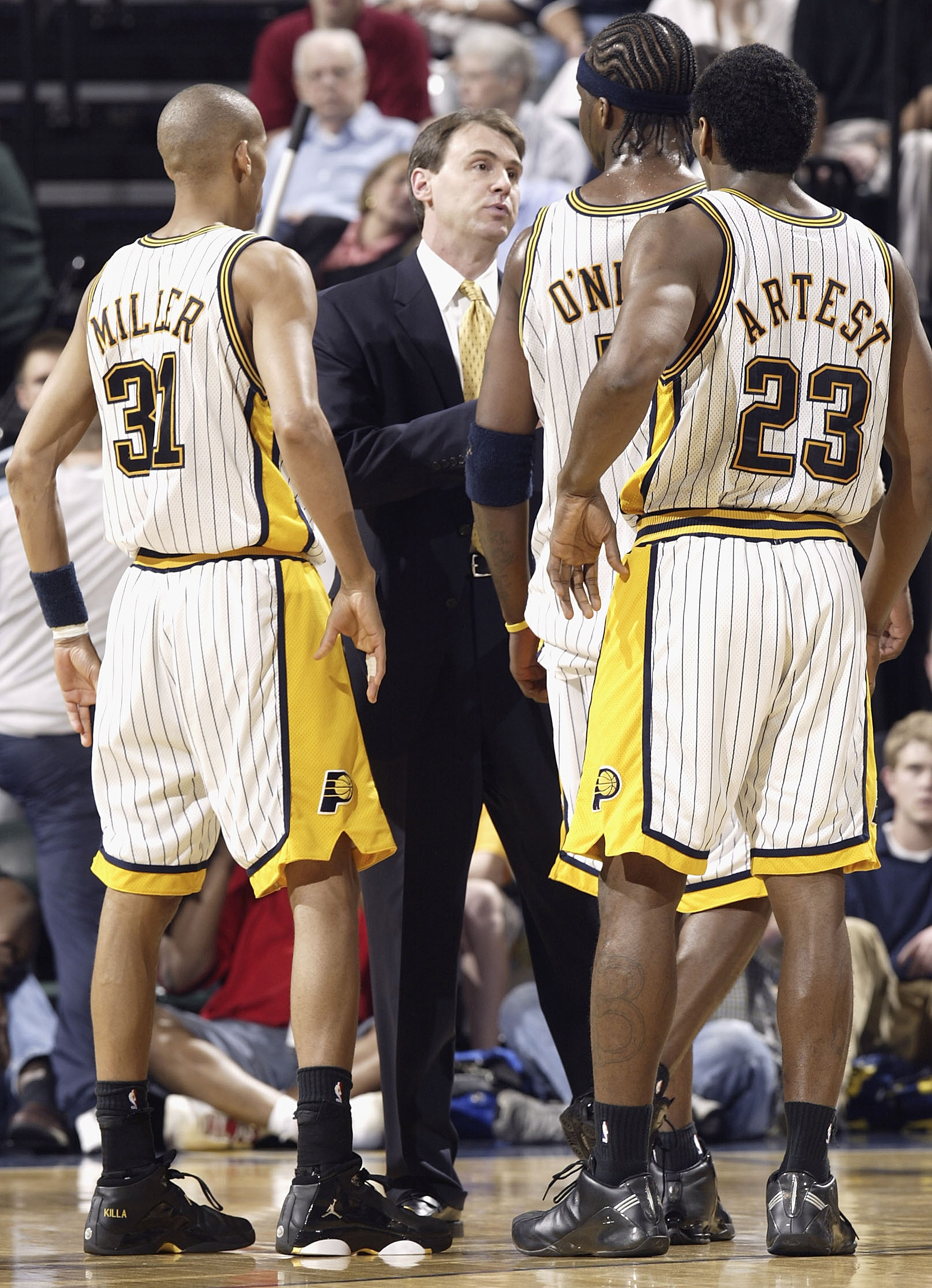 INDIANAPOLIS - APRIL 17:  Head coach Rick Carlisle of the Indiana Pacers talks with Reggie Miller #31, Jermaine O'Neal #7 and Ron Artest #23 during the game against the Boston Celtics on April 17, 2004 at the Conseco Fieldhouse in Indianapolis, Indiana. T
