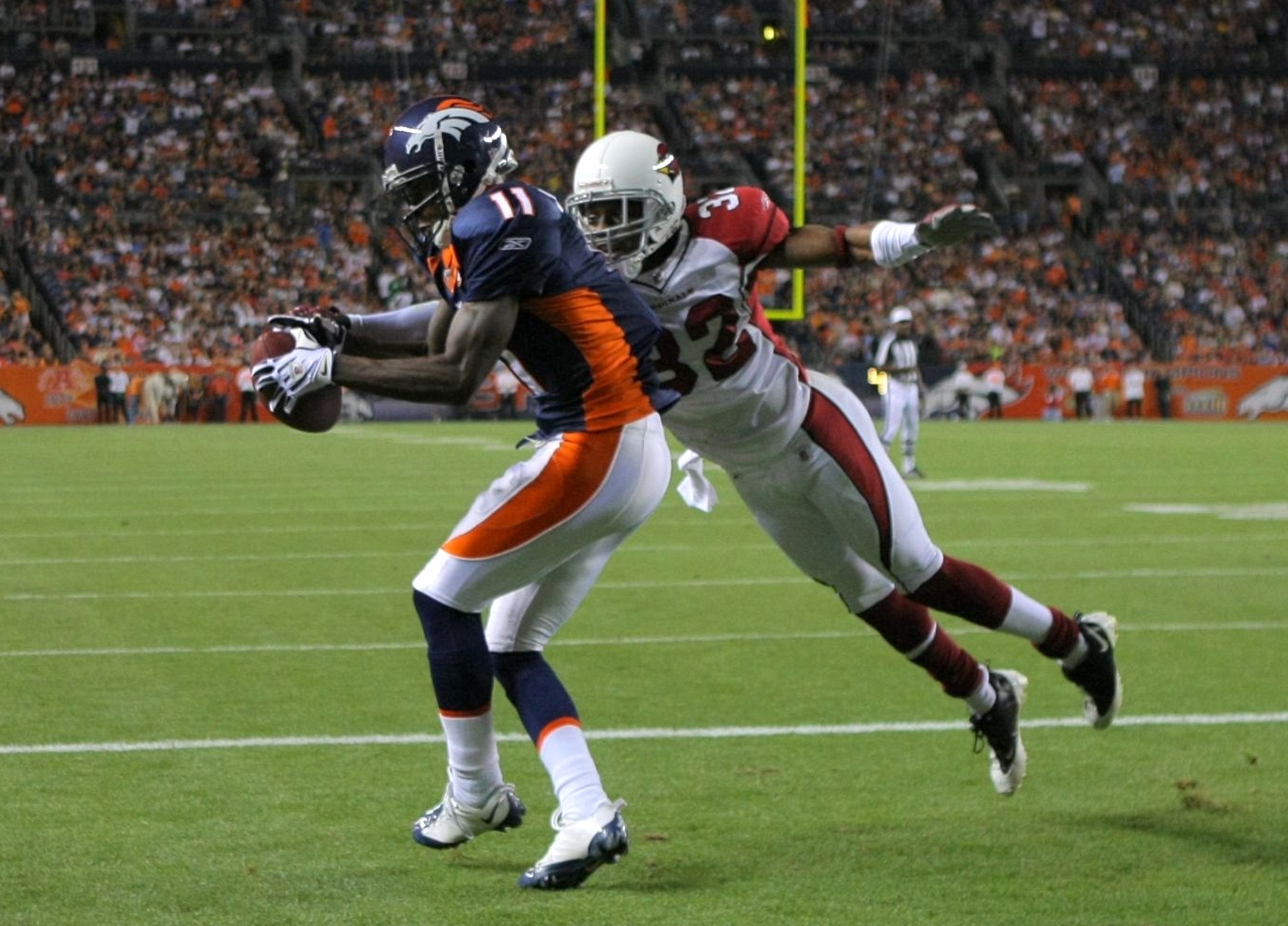 DENVER - SEPTEMBER 3: Kenny McKinley #11 of the Denver Broncos drops a touch down pass in the end zone broken up by cornerback Greg Toler #32 of the Arizona Cardinals during the NFL preseason game at Invesco Field at Mile High on September 3, 2009 in Denv