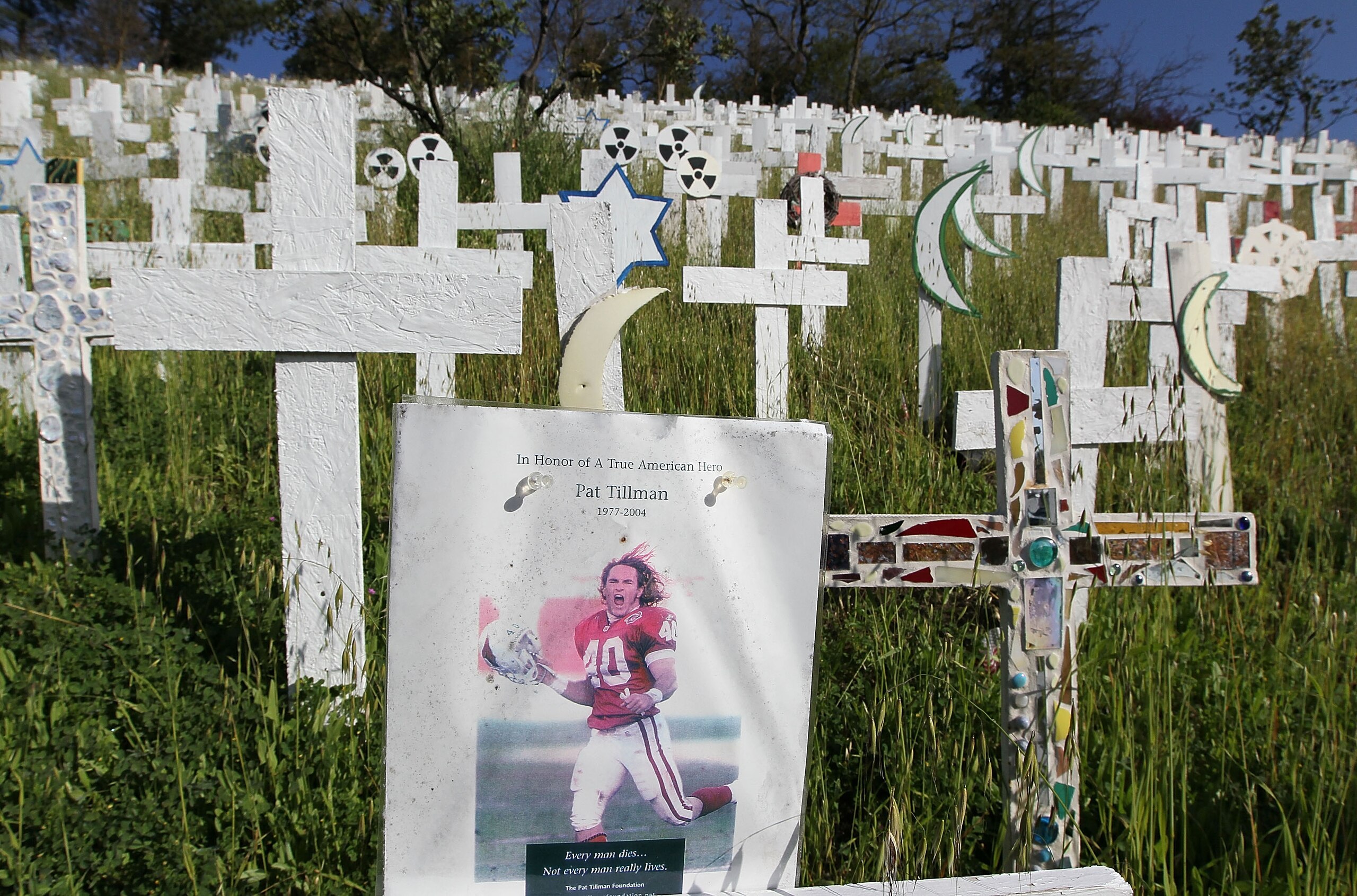 LAFAYETTE, CA - MARCH 19:  A photograph of former NFL football player and war veteran Pat Tillman is displayed on a wooden cross at a roadside memorial that features over 5,000 wooden crosses which represent U.S. troops that have been killed in Iraq March