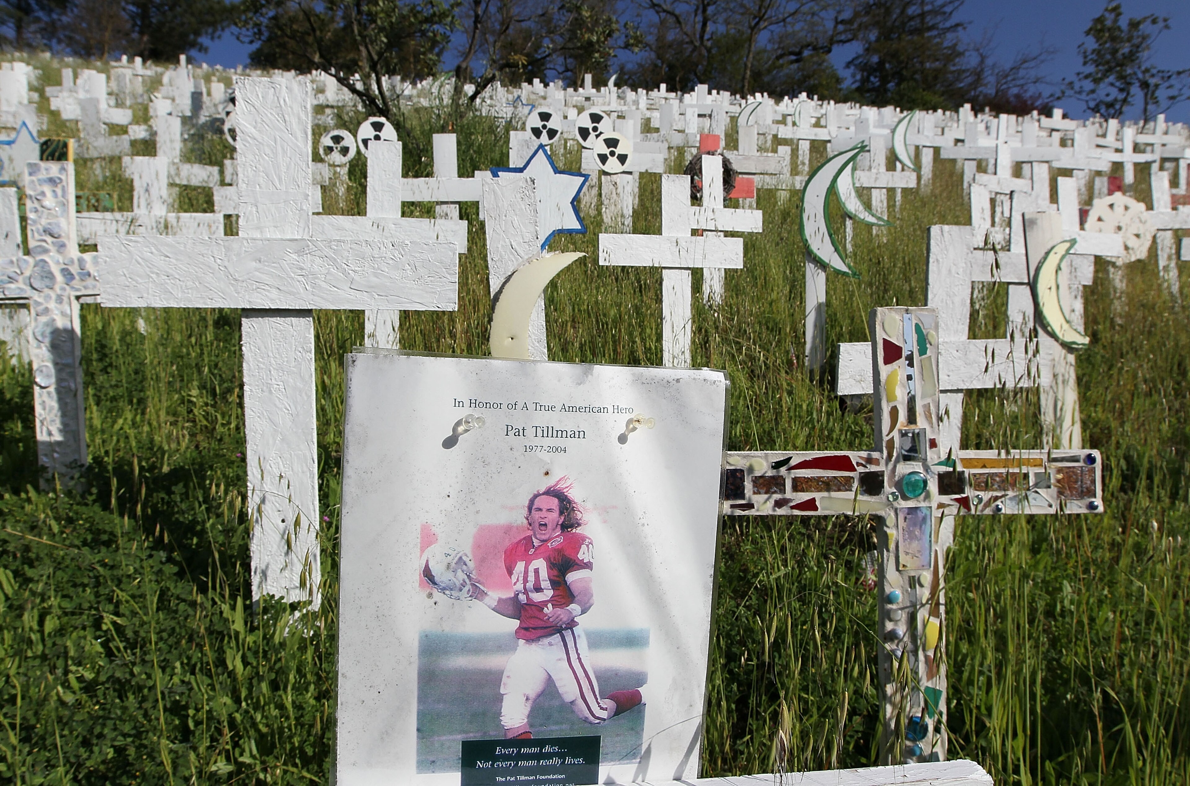 LAFAYETTE, CA - MARCH 19:  A photograph of former NFL football player and war veteran Pat Tillman is displayed on a wooden cross at a roadside memorial that features over 5,000 wooden crosses which represent U.S. troops that have been killed in Iraq March