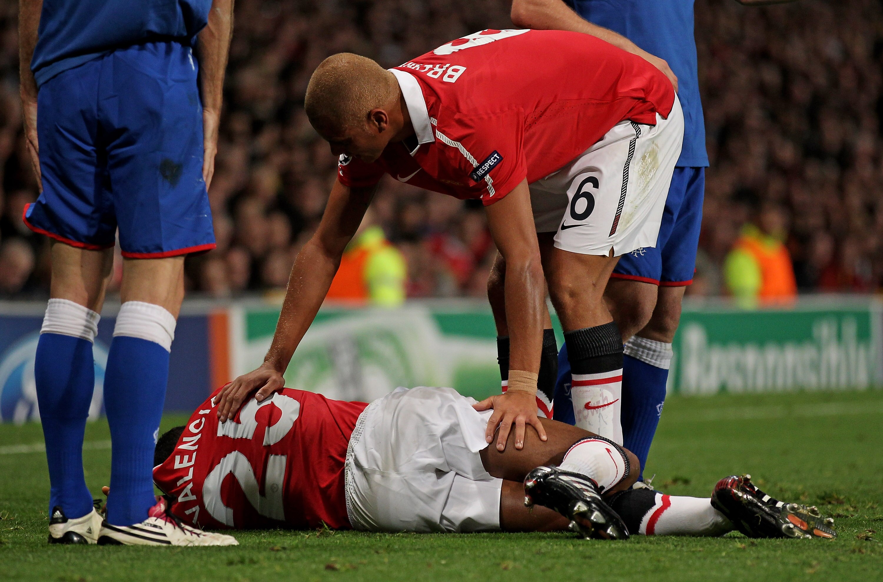 MANCHESTER, ENGLAND - SEPTEMBER 14:  Wes Brown of Manchester United comforts his injured team mate Antonio Valencia during the UEFA Champions League Group C match between Manchester United and Rangers at Old Trafford on September 14, 2010 in Manchester, E