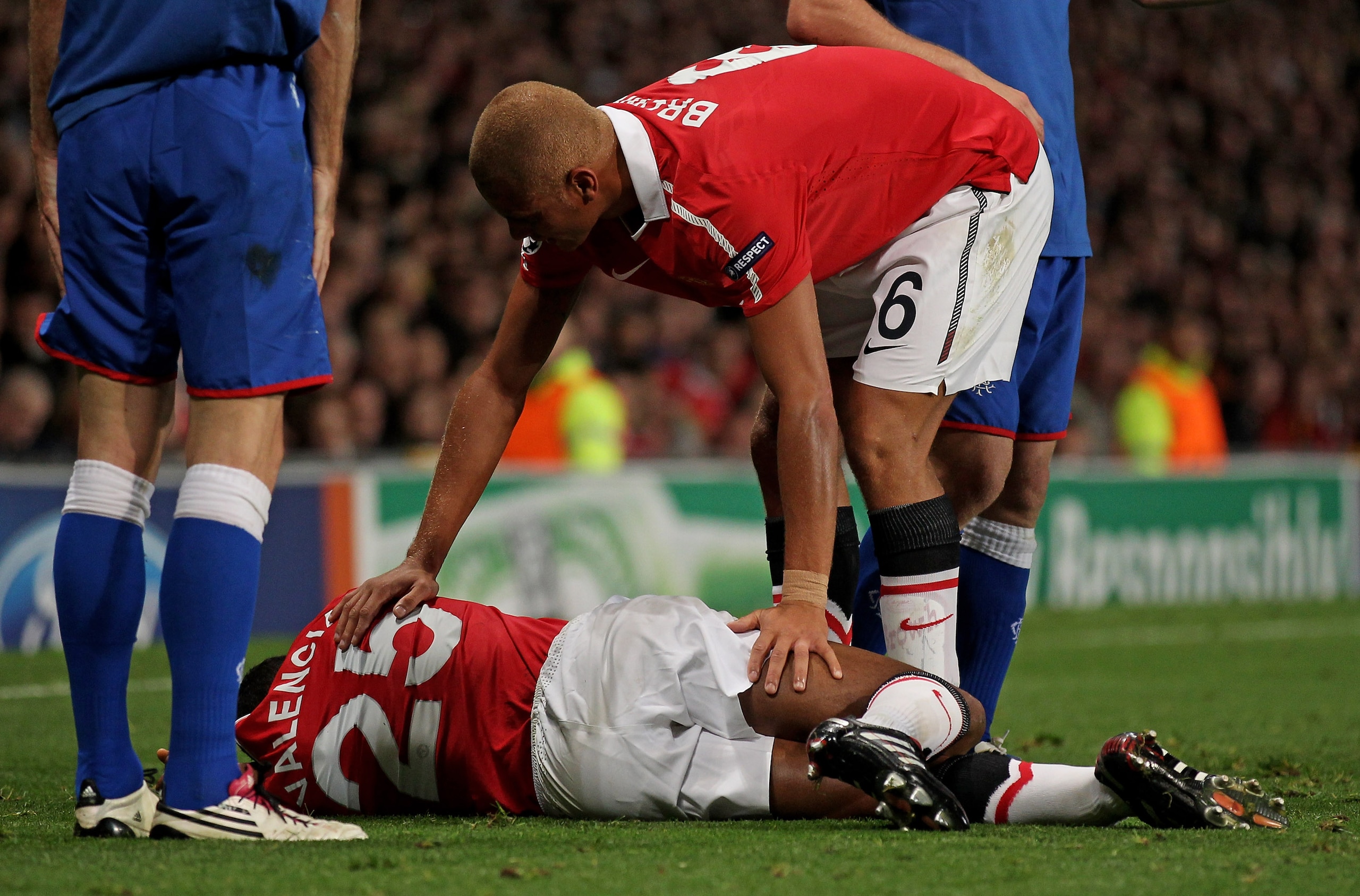 MANCHESTER, ENGLAND - SEPTEMBER 14:  Wes Brown of Manchester United comforts his injured team mate Antonio Valencia during the UEFA Champions League Group C match between Manchester United and Rangers at Old Trafford on September 14, 2010 in Manchester, E