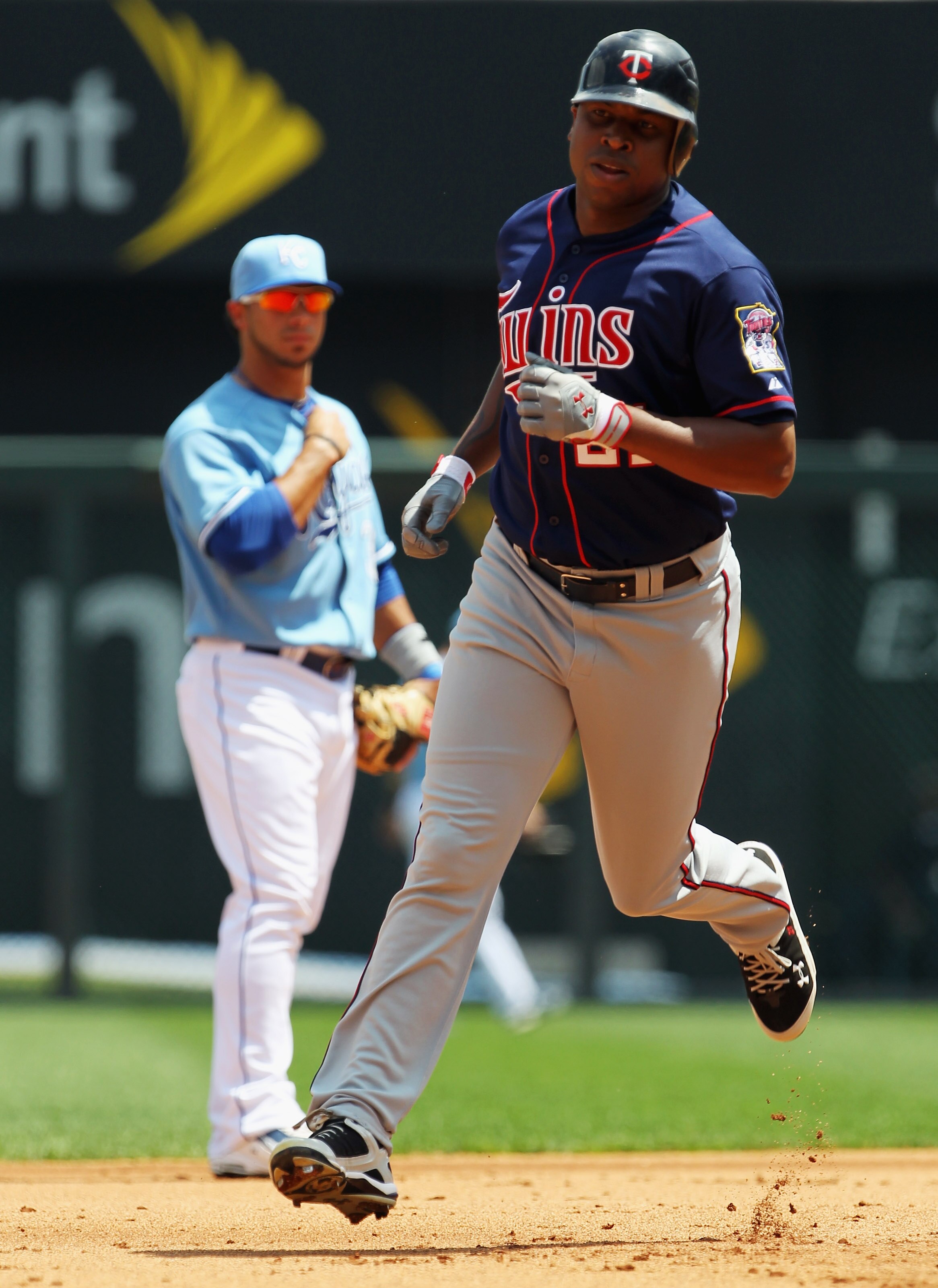KANSAS CITY, MO - JULY 28:  Delmon Young #21 of the Minnesota Twins rounds the bases after hitting a 3-run home run as Mike Aviles #30 of the Kansas City Royals looks on during the 1st inning of the game on July 28, 2010 at Kauffman Stadium in Kansas City