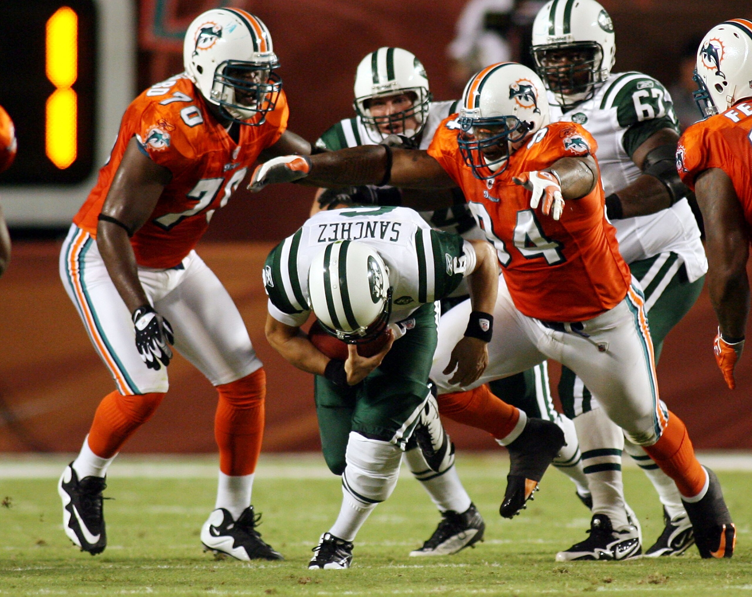 MIAMI - OCTOBER 12:  Quarterback Mark Sanchez #6 of the New York Jets is sacked by defensive end Randy Starks #94 of the Miami Dolphins at Land Shark Stadium on October 12, 2009 in Miami, Florida.  (Photo by Marc Serota/Getty Images)