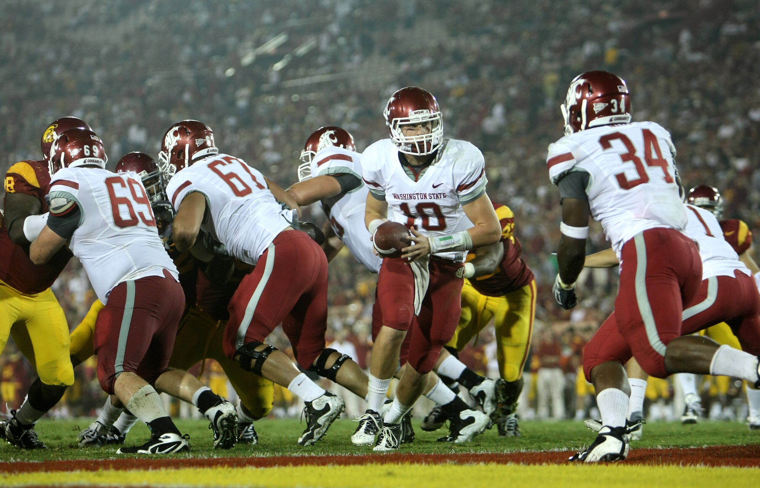 LOS ANGELES, CA - SEPTEMBER 26:  Quarterback Jeff Tuel #10 of the Washington State Cougars turns to hand off to running back Logwone Mitz #34 against the USC Trojans on September 23, 2009 at the Los Angeles Coliseum in Los Angeles, California.  USC won 27