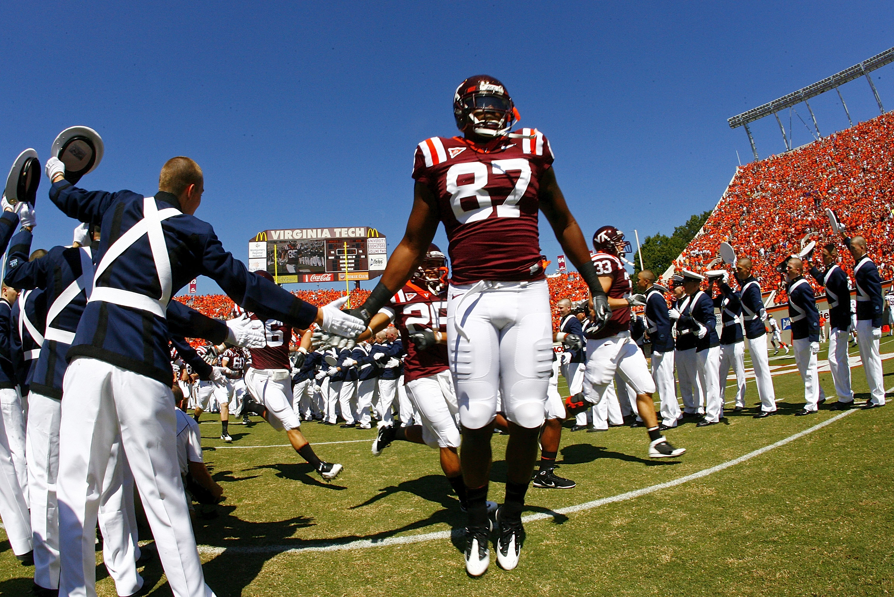 BLACKSBURG, VA - SEPTEMBER 18: Tight end Prince Parker #87 of the Virginia Tech Hokies is greeted by a member of the Virginia Tech 'Highty Tighties' regimental band on field prior to the Hokies game against the East Carolina Pirates at Lane Stadium on Sep