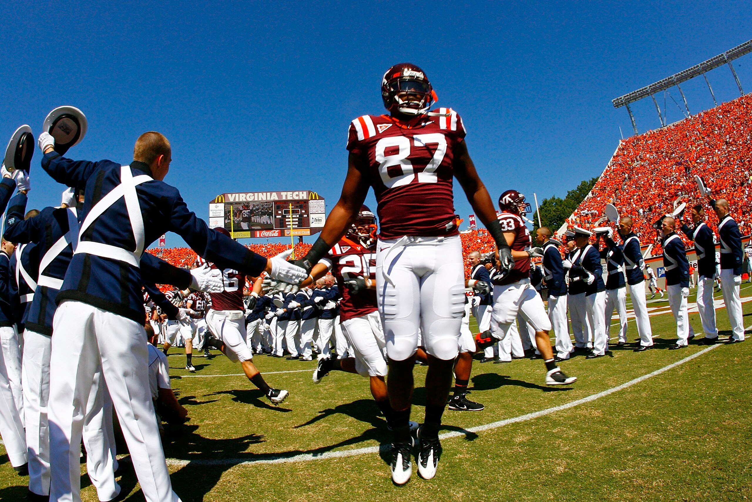 BLACKSBURG, VA - SEPTEMBER 18: Tight end Prince Parker #87 of the Virginia Tech Hokies is greeted by a member of the Virginia Tech 'Highty Tighties' regimental band on field prior to the Hokies game against the East Carolina Pirates at Lane Stadium on Sep
