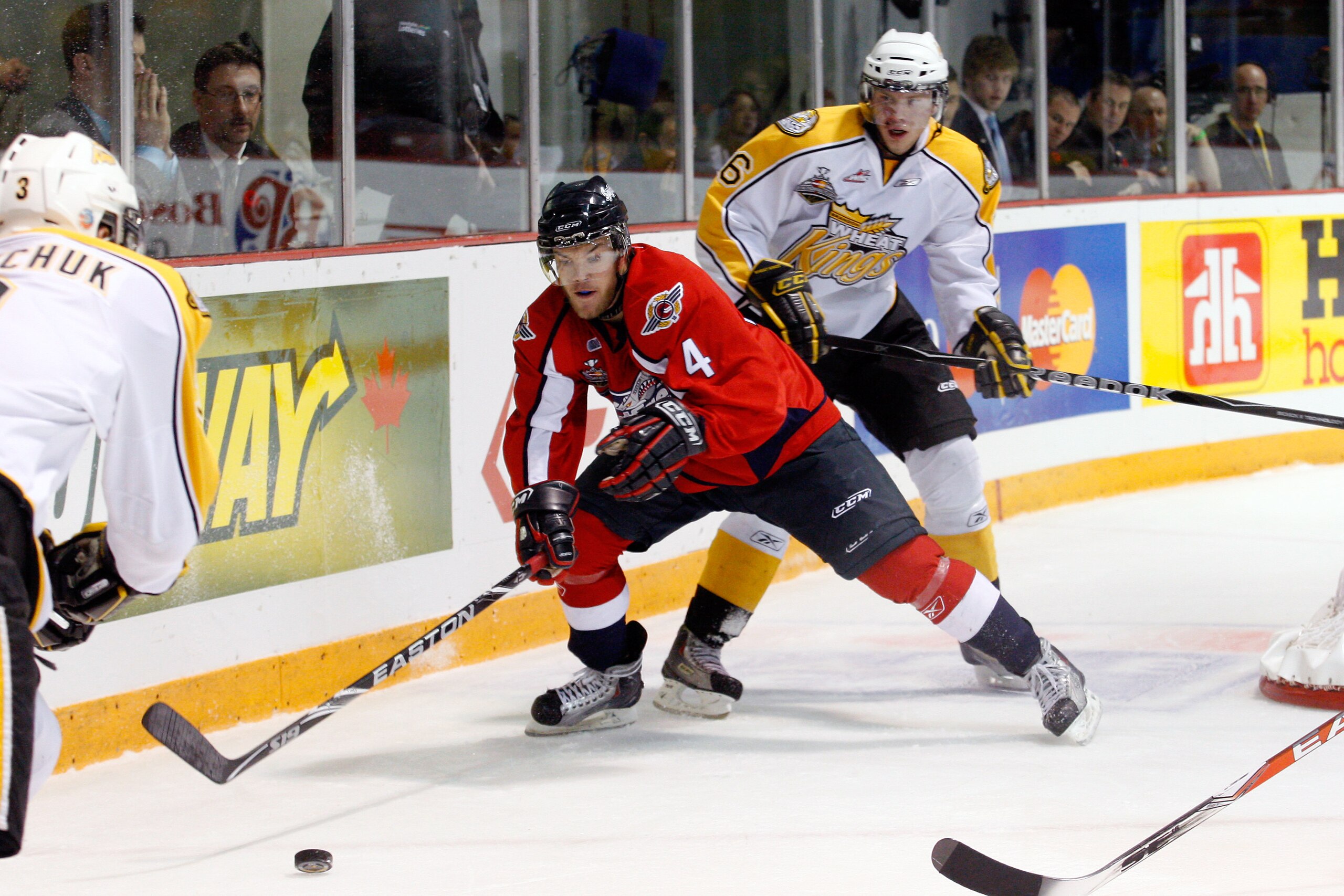 BRANDON, CANADA - MAY 23: Taylor Hall #4 of the Windsor Spitfires battles for the puck with Brodie Melnychuk #3 and Alexander Urbom #26 of the Brandon Wheat Kings during the Final of the 2010 Mastercard Memorial Cup Tournament at the Keystone Centre on Ma