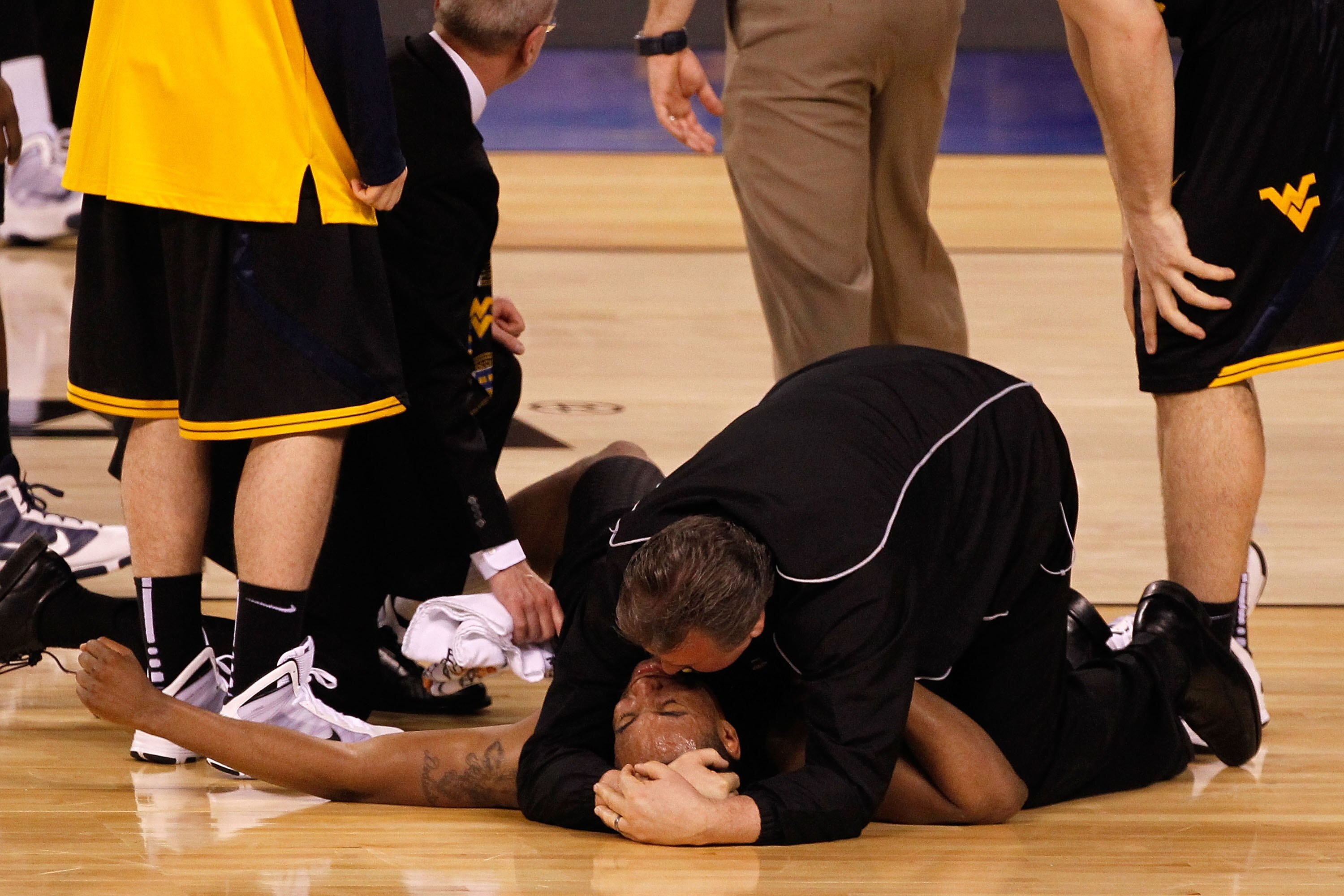 INDIANAPOLIS - APRIL 03:  Head coach Bob Huggins consoles Da'Sean Butler #1 of the West Virginia Mountaineers after Butler injured his knee in the second half against the Duke Blue Devils during the National Semifinal game of the 2010 NCAA Division I Men'
