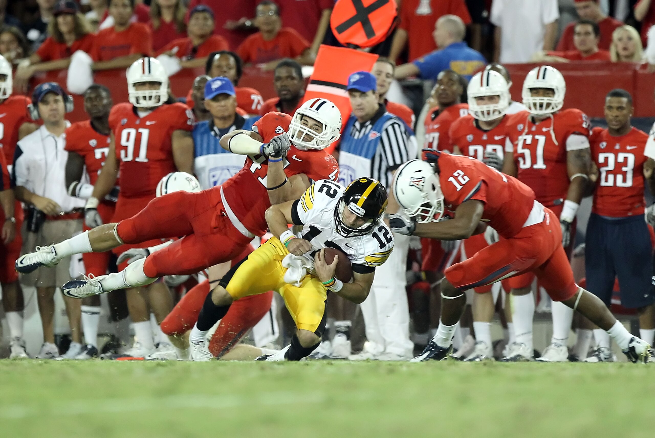 TUCSON, AZ - SEPTEMBER 18:  Quarterback Ricky Stanzi #12 of the Iowa Hawkeyes is tackled by Paul Vassallo #41 and Adam Hall #12 of the Arizona Wildcats during the college football game at Arizona Stadium on September 18, 2010 in Tucson, Arizona.  The Wild