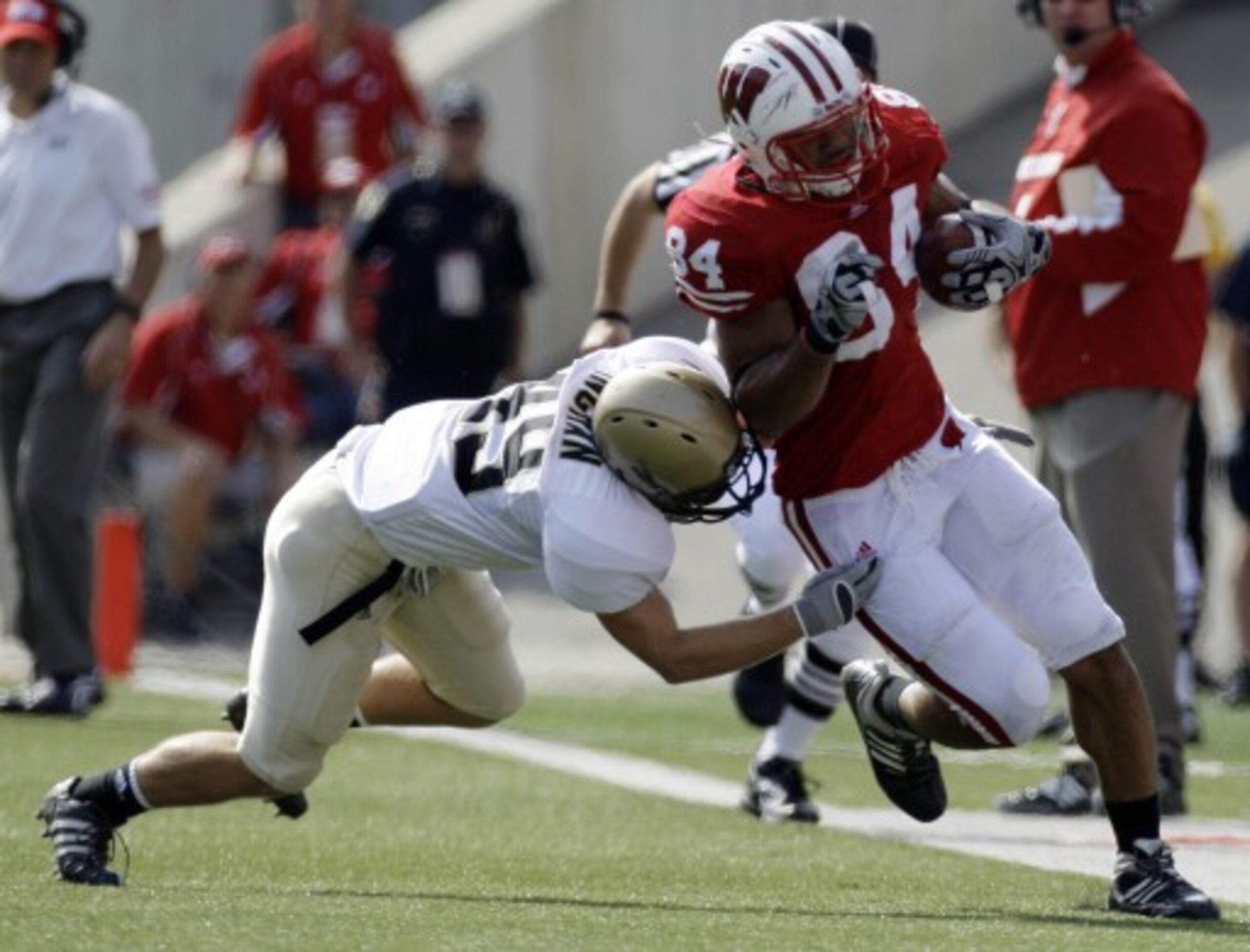 LAS VEGAS - SEPTEMBER 04:  John Clay #32 of the Wisconsin Badgers tries to get away from Deante' Purvis #26 of the UNLV Rebels during the first quarter of their game at Sam Boyd Stadium September 4, 2010 in Las Vegas, Nevada.  (Photo by Ethan Miller/Getty