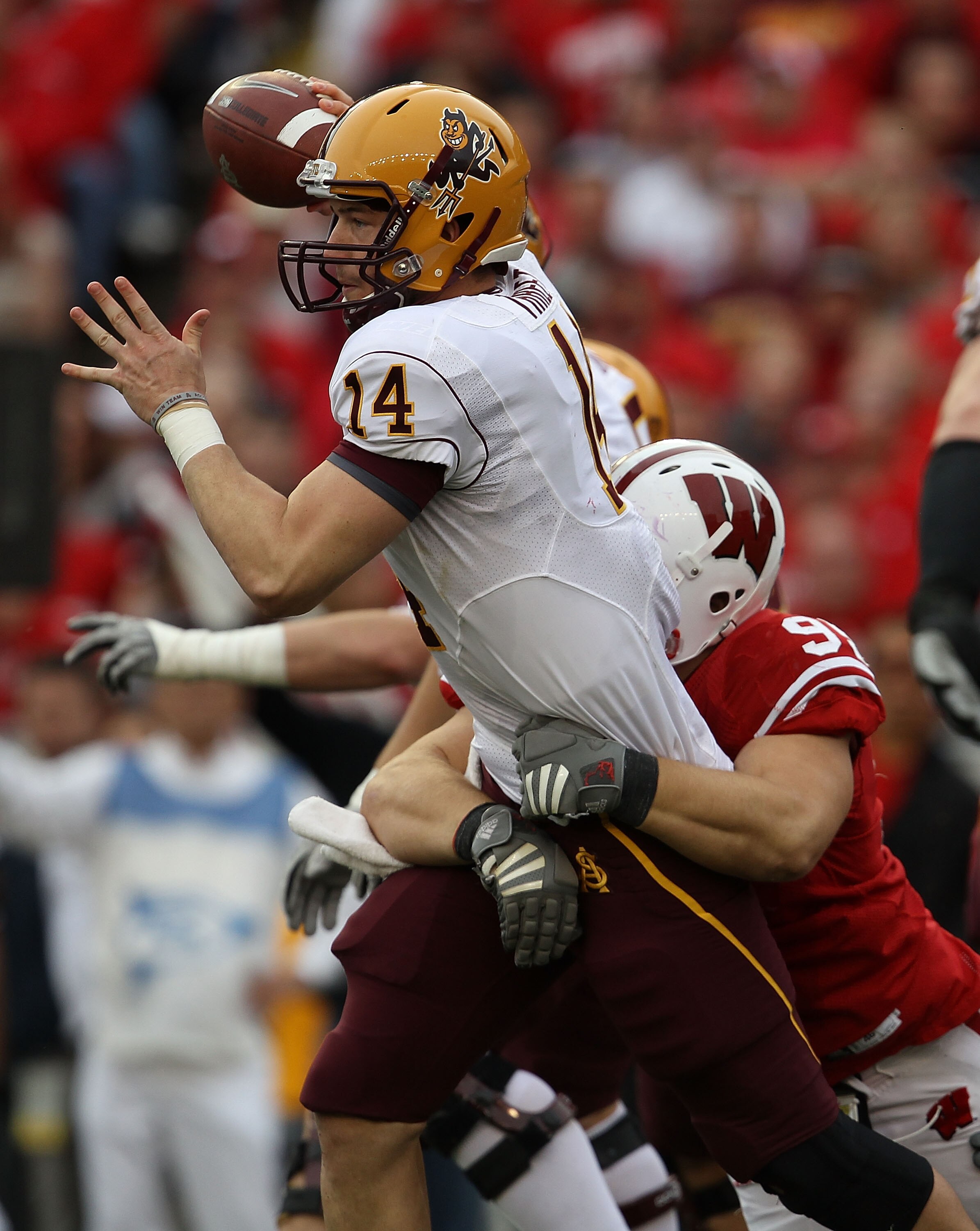 MADISON, WI - SEPTEMBER 18: Steven Threet #14 of the Arizona State Sun Devils tries to pass as  Patrick Butrym #95 of the Wisconsin Badgers drags him down at Camp Randall Stadium on September 18, 2010 in Madison, Wisconsin. Wisconsin defeated Arizona Stat