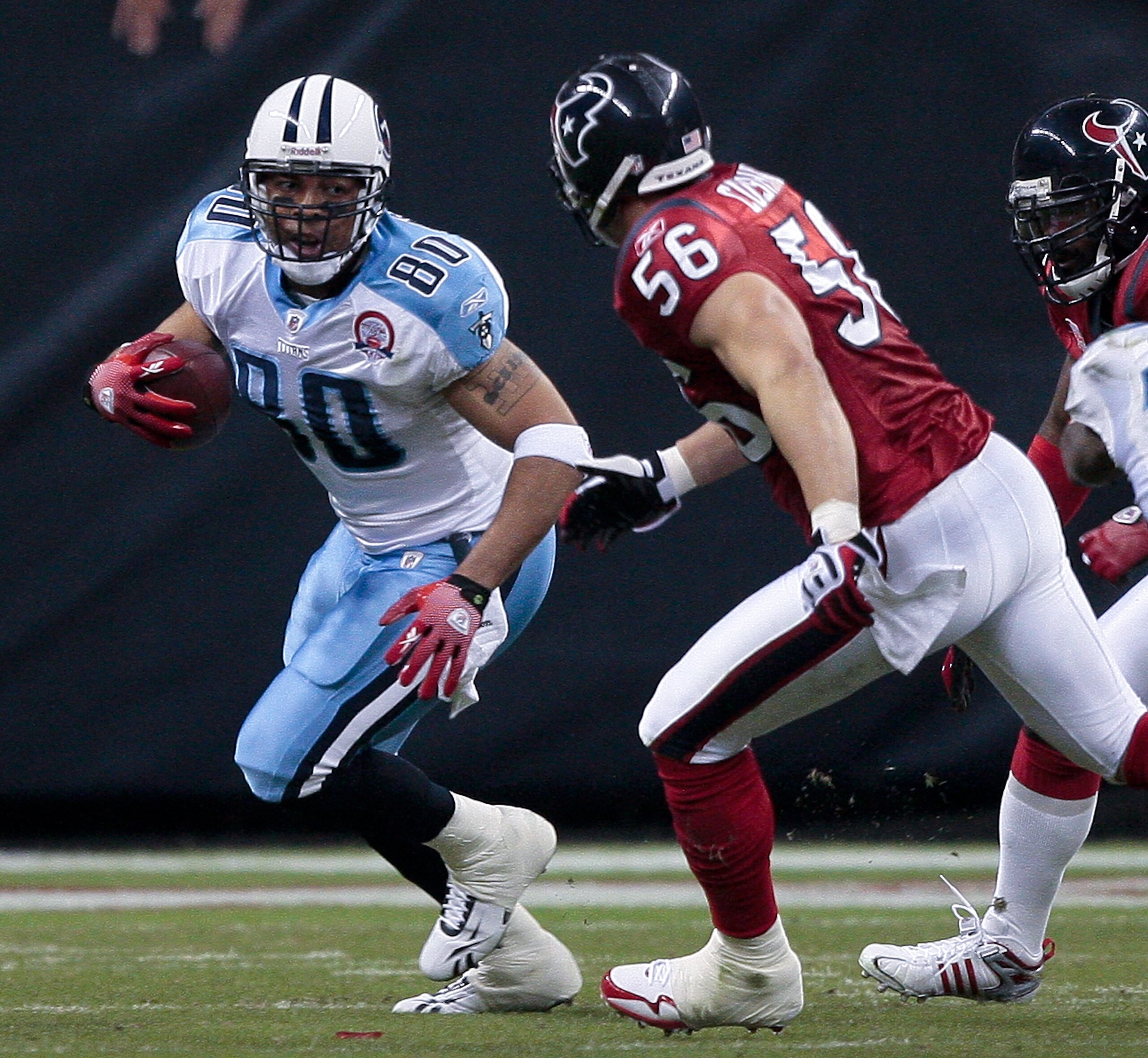 HOUSTON - NOVEMBER 23:  Tight-end Bo Scaife #80 of the Tennessee Titans looks for room to run after a reception as linebacker Brian Cushing #56 of the Houston Texans positions to make a tackle at Reliant Stadium on November 23, 2009 in Houston, Texas.  (P
