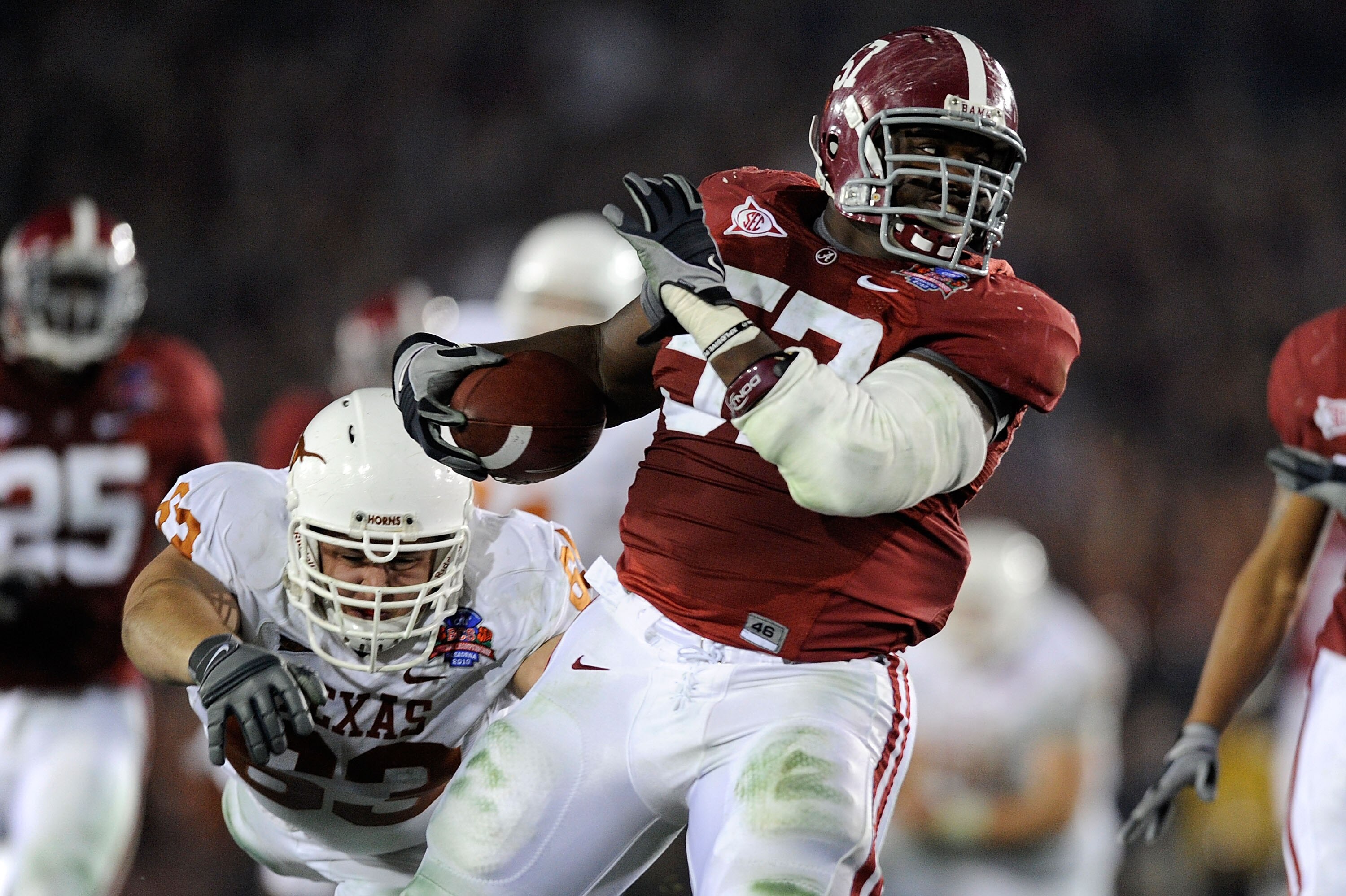 PASADENA, CA - JANUARY 07:  Lineman Marcell Dareus #57 of the Alabama Crimson Tide runs with the ball after an interception as guard Michael Huey #63 of the Texas Longhorns attempts to tackle during the second quarter of the Citi BCS National Championship