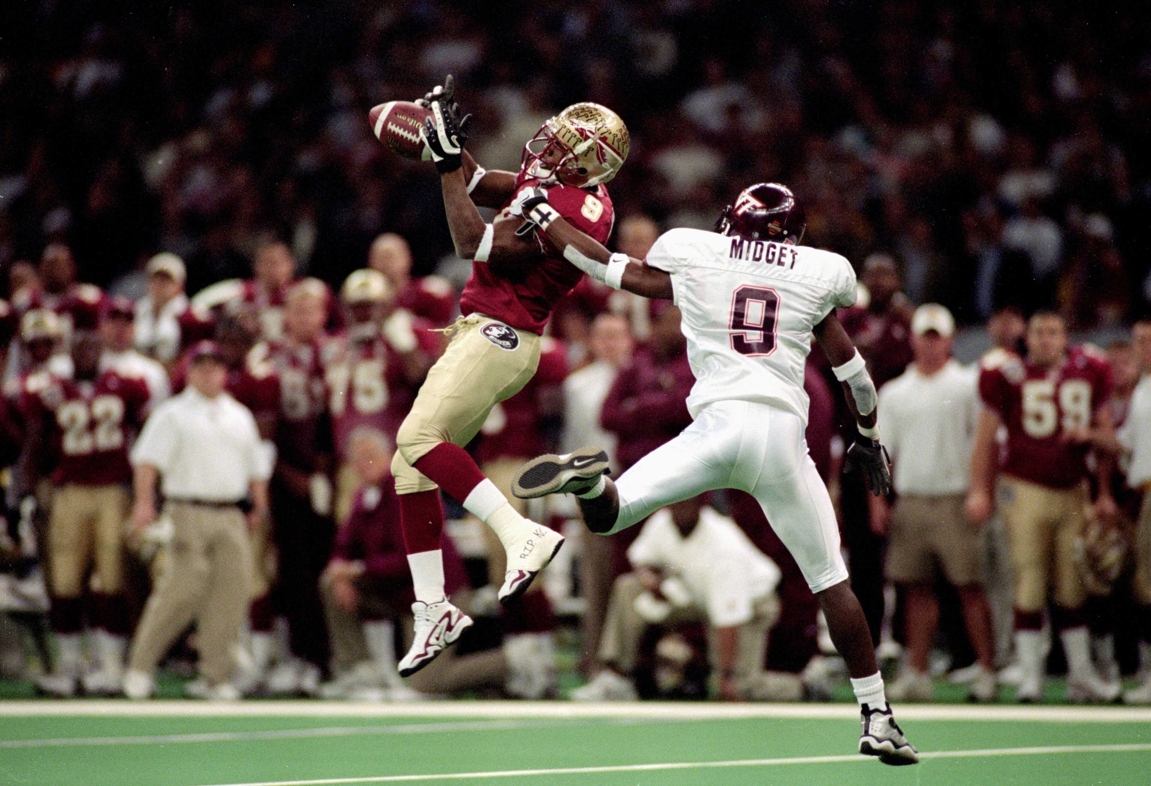 5 Jan 2000:  Peter Warrick #9 of the Florida State Seminoles jumps and catches the ball as Anthony Midget #9 of the Virginia Tech Hokies gaurds him during the Nokita Sugar Bowl Game at the Louisiana Superdome in New Orleans, Louisiana. The Seminoles defea