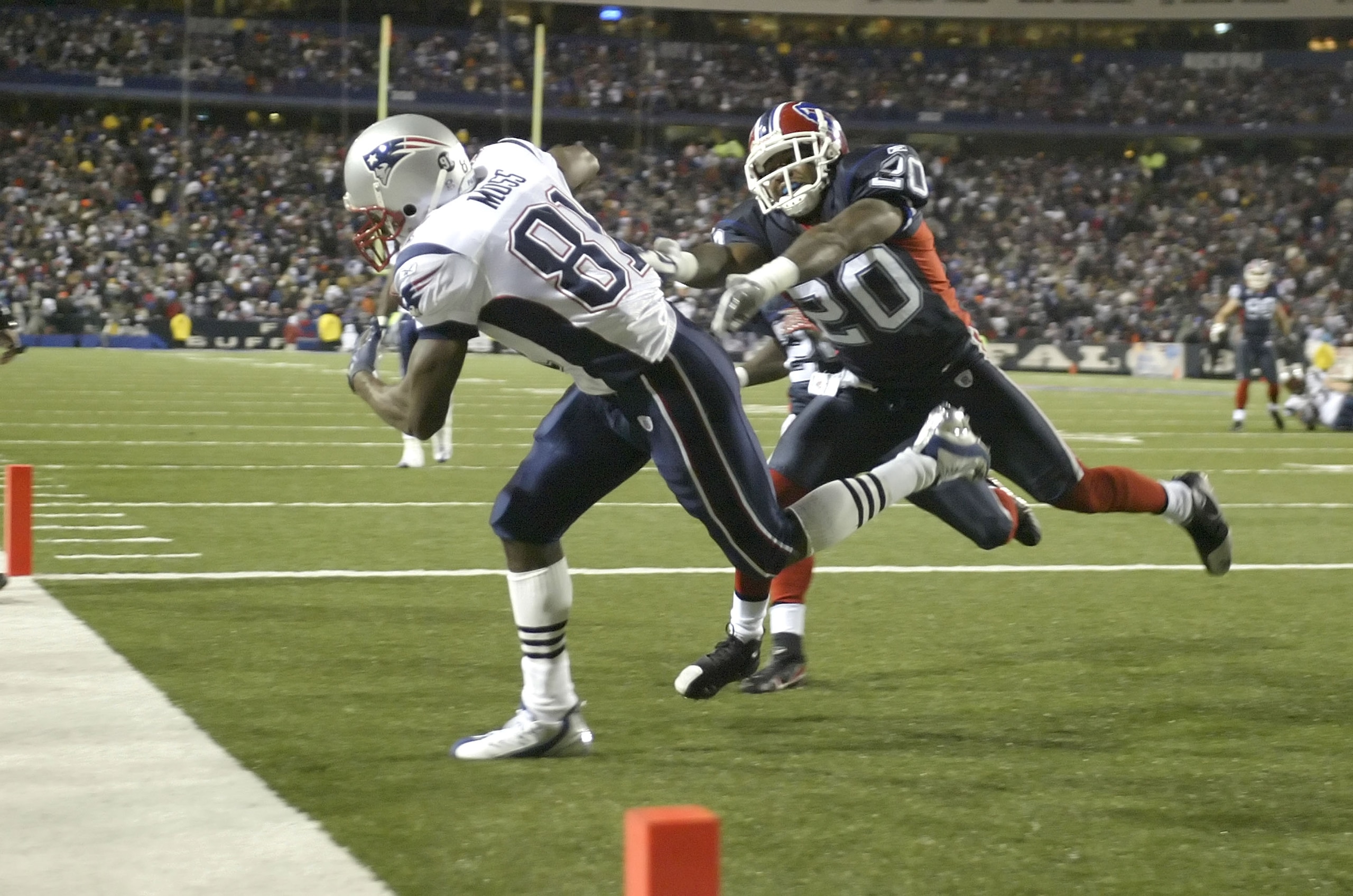 BUFFALO, NY - NOVEMBER 18:  Randy Moss #81 of the New England Patriots scores his fourth touchdown of the first half ahead of Donte Whitner #20 of the Buffalo Bills at Ralph Wilson Stadium November 18, 2007 in Orchard Park, New York.  (Photo by Rick Stewa