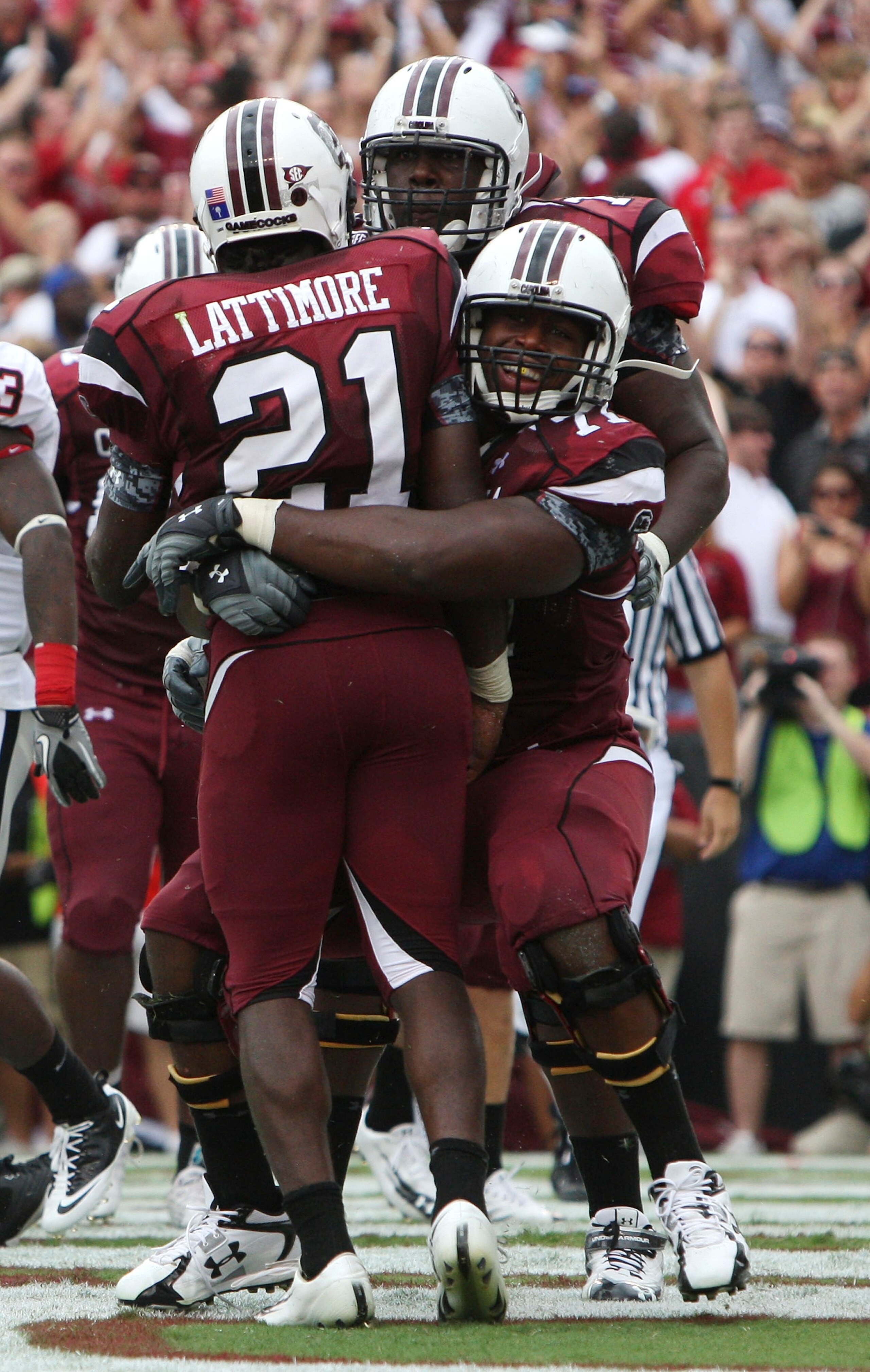 COLUMBIA, SC - SEPTEMBER 11: Tailback Marcus Lattimore #21 of the South Carolina Gamecocks is hugged by teammates after Lattimore's first quarter touchdown during the game against the Georgia Bulldogs at Williams-Brice Stadium on September 11, 2010 in Col COLUMBIA, SC - SEPTEMBER 11: Tailback Marcus Lattimore #21 of the South Carolina Gamecocks is hugged by teammates after Lattimore's first quarter touchdown during the game against the Georgia Bulldogs at Williams-Brice Stadium on September 11, 2010 in Col