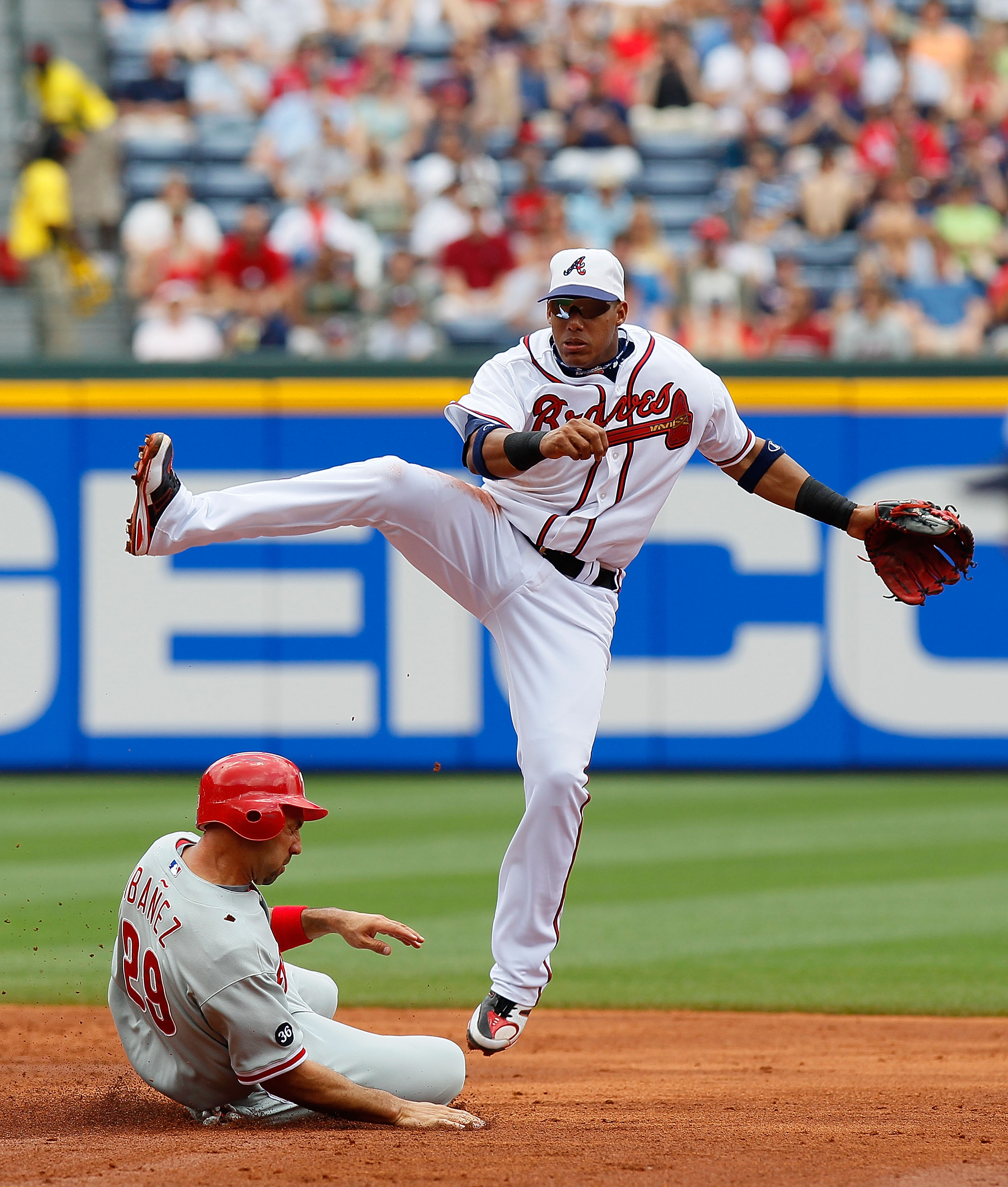 ATLANTA - MAY 31:  Yunel Escobar #19 of the Atlanta Braves leaps as he turns a double play over Raul Ibanez #29 of the Philadelphia Phillies at Turner Field on May 31, 2010 in Atlanta, Georgia.  (Photo by Kevin C. Cox/Getty Images)