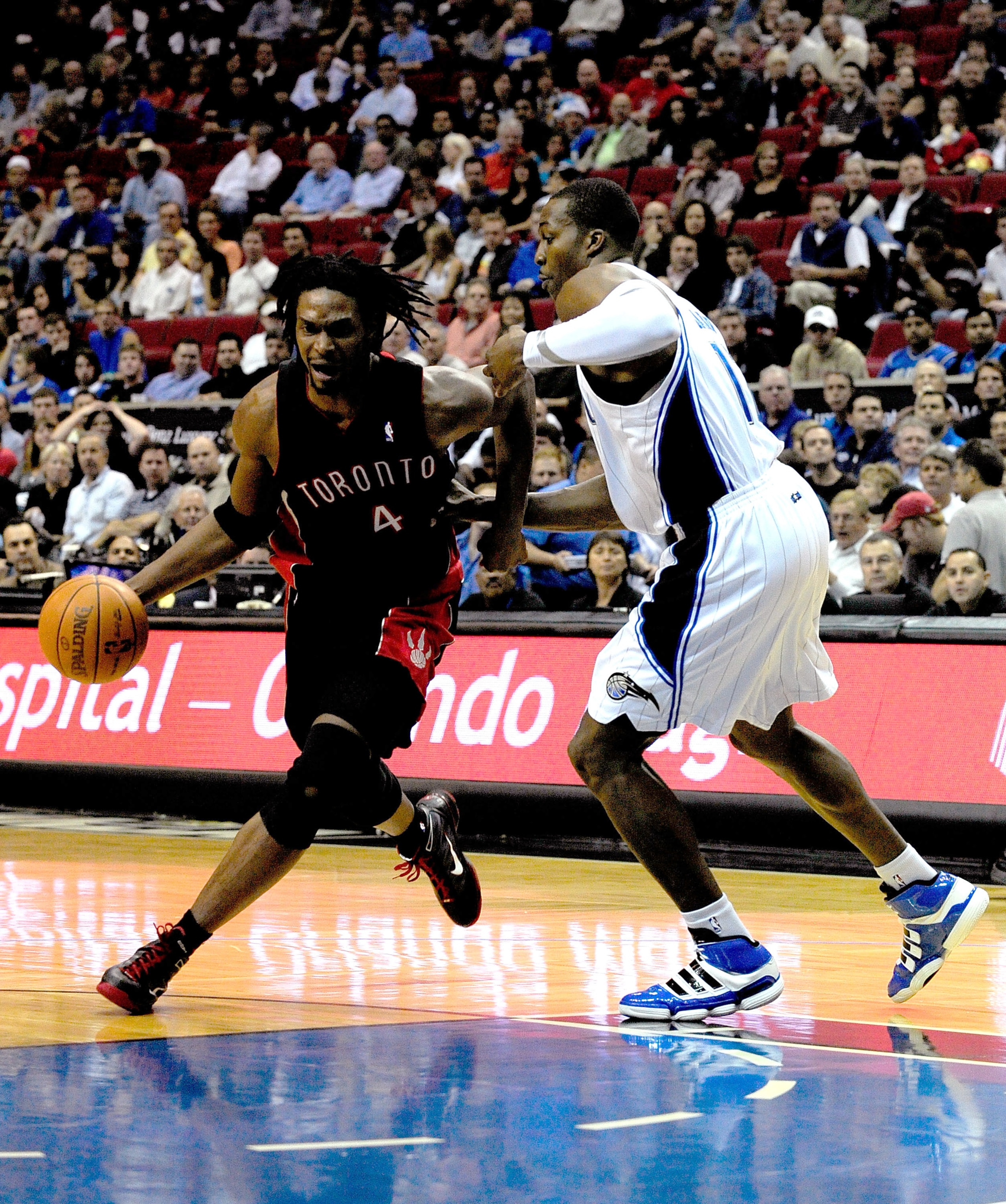 ORLANDO, FL - DECEMBER 16:  Chris Bosh #4 of the Toronto Raptors attempts to drives past Dwight Howard #12 of the Orlando Magic during the game at Amway Arena on December 16, 2009 in Orlando, Florida.  NOTE TO USER: User expressly acknowledges and agrees