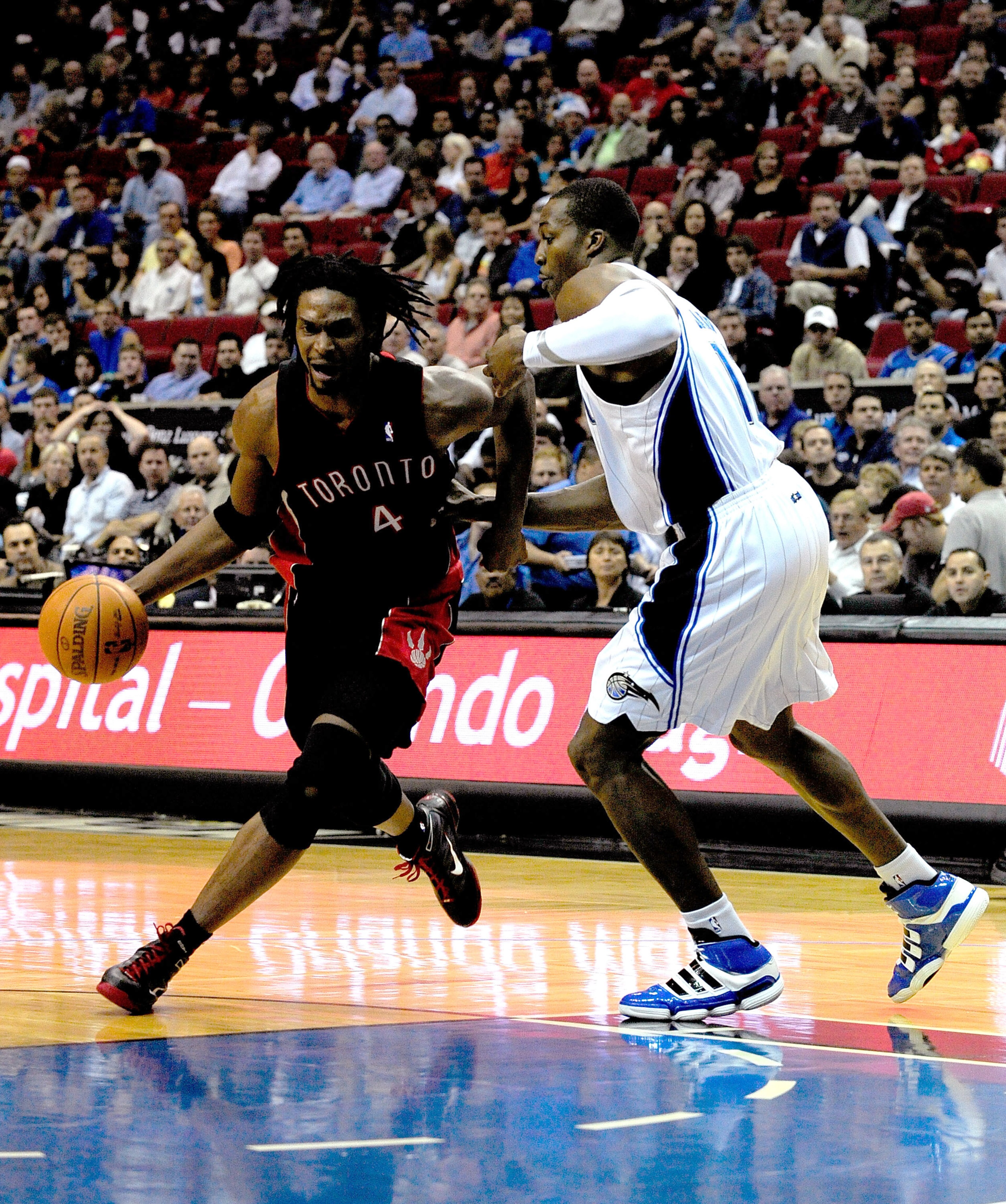 ORLANDO, FL - DECEMBER 16: Chris Bosh #4 of the Toronto Raptors attempts to drives past Dwight Howard #12 of the Orlando Magic during the game at Amway Arena on December 16, 2009 in Orlando, Florida. NOTE TO USER: User expressly acknowledges and agrees ORLANDO, FL - DECEMBER 16: Chris Bosh #4 of the Toronto Raptors attempts to drives past Dwight Howard #12 of the Orlando Magic during the game at Amway Arena on December 16, 2009 in Orlando, Florida. NOTE TO USER: User expressly acknowledges and agrees