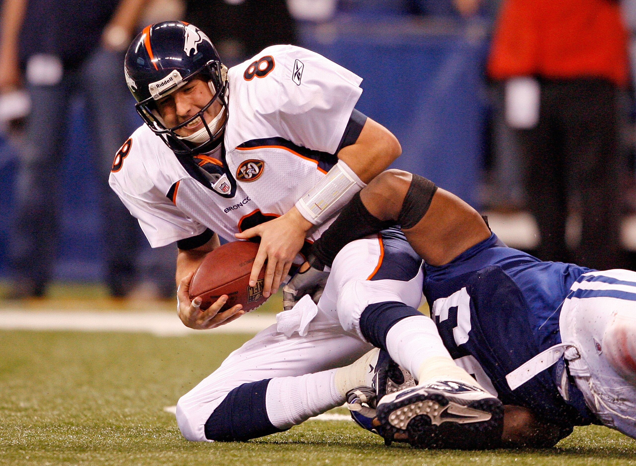 INDIANAPOLIS - DECEMBER 13:  Kyle Orton #8 of the Denver Broncos is sacked by Dwight Freeney #93 of the Indianapolis Colts during the NFL game at Lucas Oil Stadium on December 13, 2009 in Indianapolis, Indiana. The Colts won 28-16.  (Photo by Andy Lyons/G