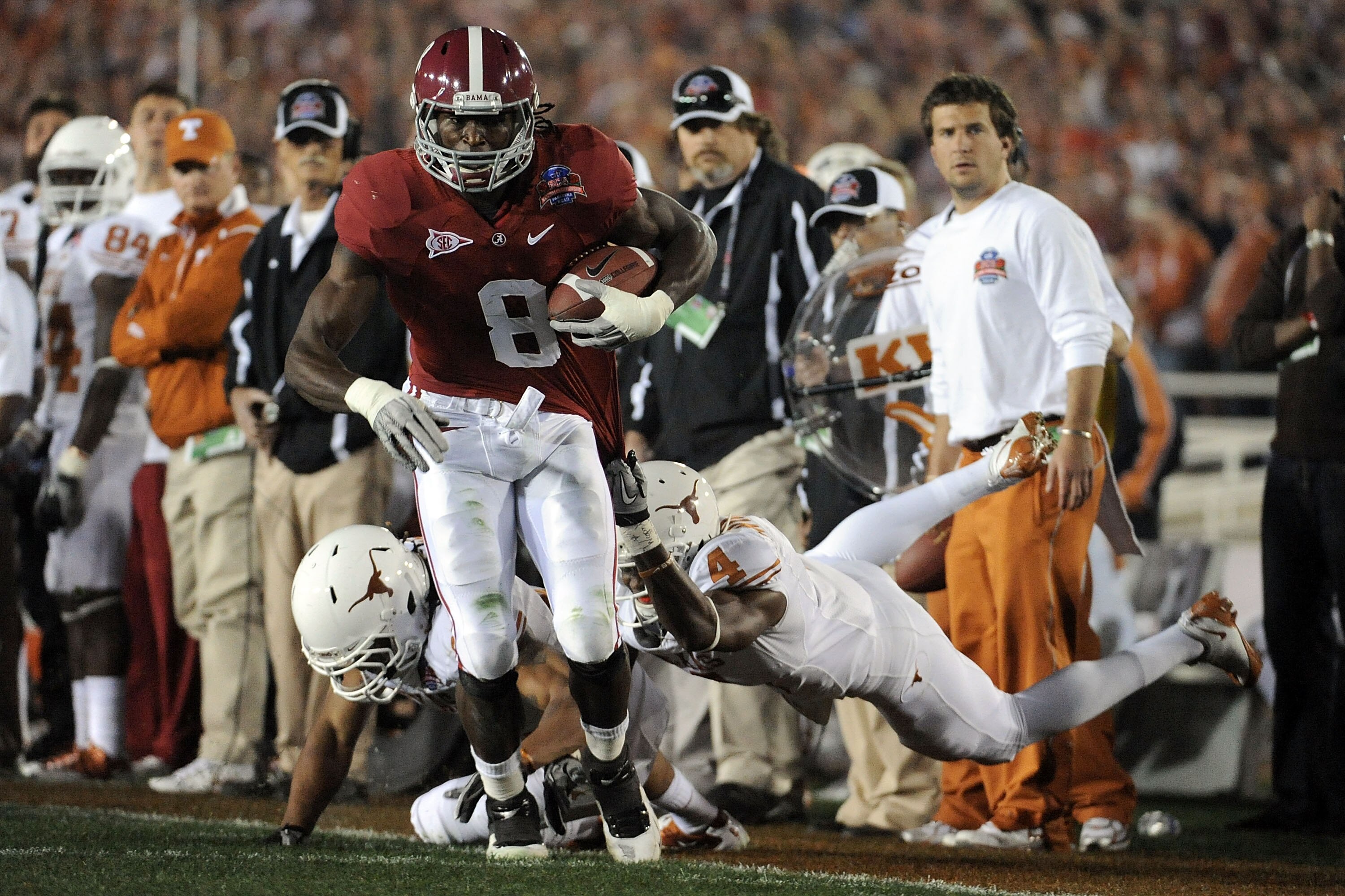 PASADENA, CA - JANUARY 07:  Wide receiver Julio Jones #8 of the Alabama Crimson Tide runs with the ball as he is grabbed by cornerback Aaron Williams #4 of the Texas Longhorns during the Citi BCS National Championship game at the Rose Bowl on January 7, 2