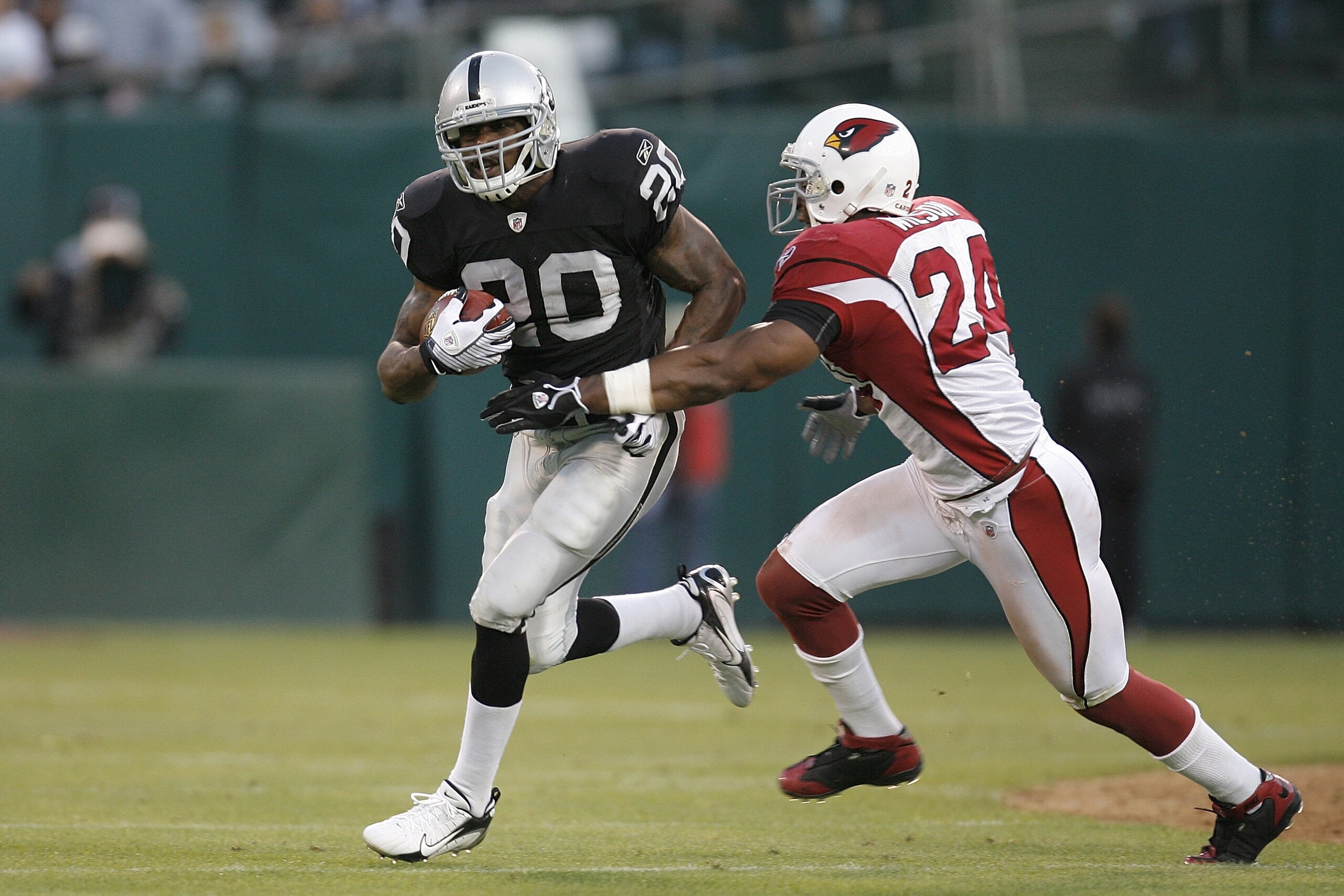 OAKLAND, CA - AUGUST 23: Running back Darren McFadden #20 of the Oakland Raiders avoids defensive back Adrian Wilson #24 of the Arizona Cardinals during a preseason game on August 23, 2008 at the McAfee Coliseum in Oakland, California. (Photo by Greg Tr OAKLAND, CA - AUGUST 23: Running back Darren McFadden #20 of the Oakland Raiders avoids defensive back Adrian Wilson #24 of the Arizona Cardinals during a preseason game on August 23, 2008 at the McAfee Coliseum in Oakland, California. (Photo by Greg Tr