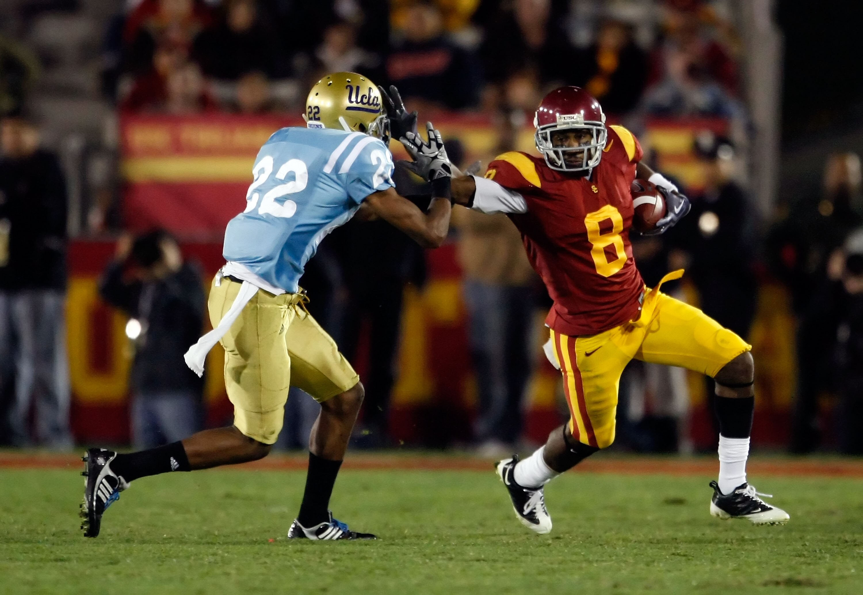 LOS ANGELES, CA - NOVEMBER 28:  Ronald Johnson #8 of the USC Trojans stiff arms Sheldon Price #22 of the UCLA Bruins in the second half at the Los Angeles Memorial Coliseum on November 28, 2009 in Los Angeles, California. USC defeated UCLA 28-7.  (Photo b