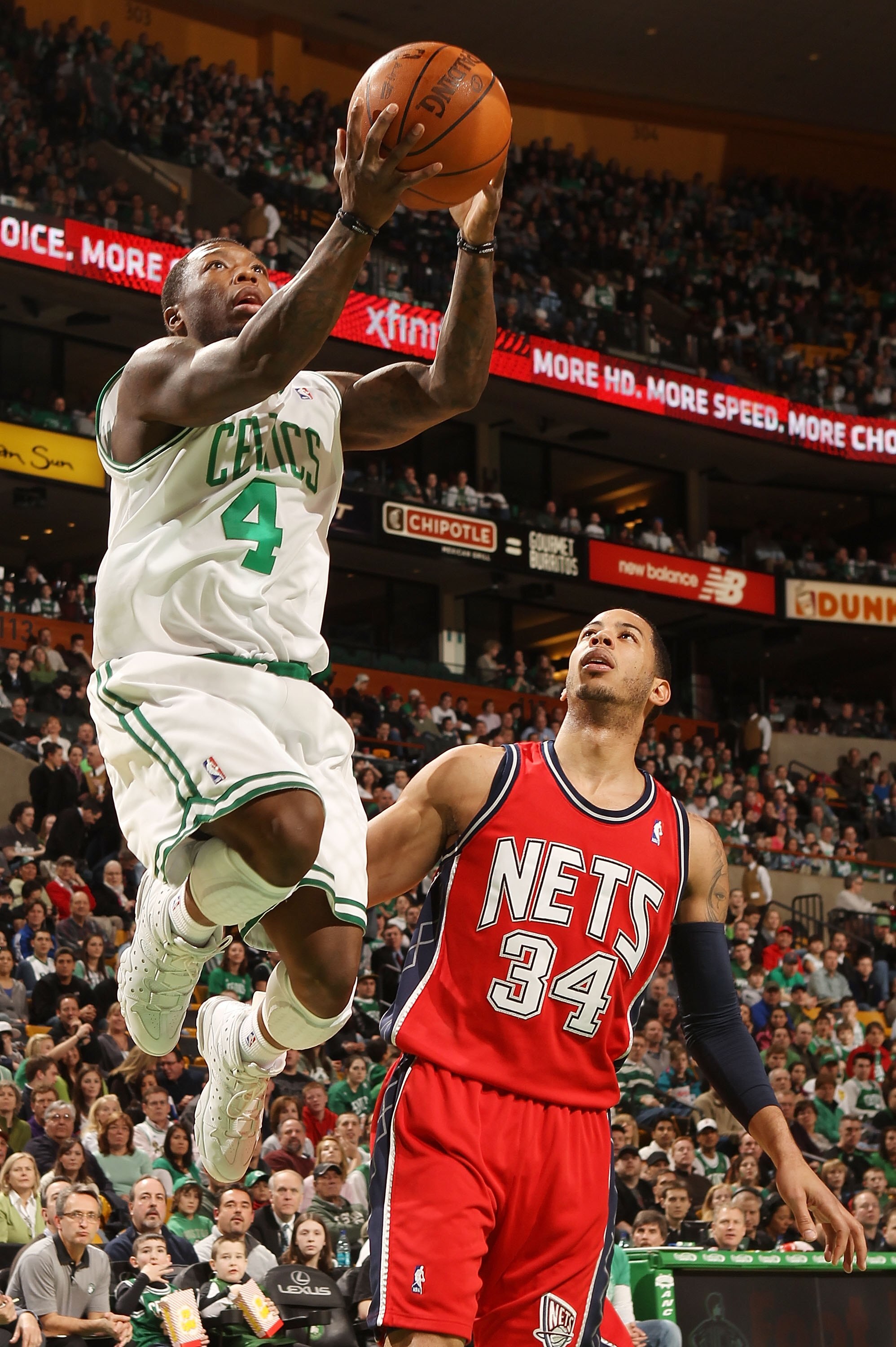 BOSTON - FEBRUARY 27:  Nate Robinson #4 of the Boston Celtics takes a shot as Devin Harris #34 of the New Jersey Nets defends at the TD Garden on February 27, 2010 in Boston, Massachusetts. The Nets defeated the Celtics 104-96.  NOTE TO USER: User express