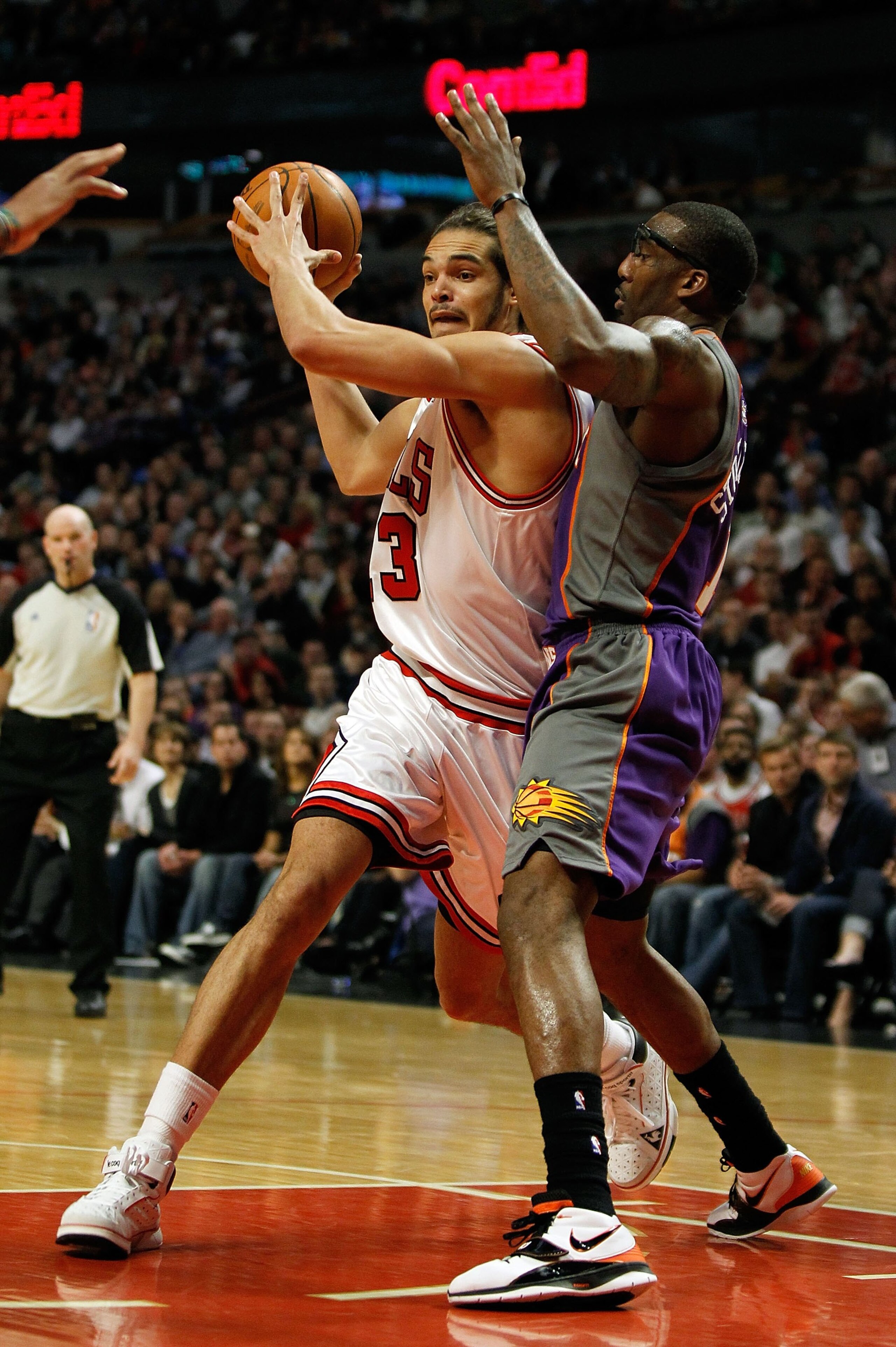 CHICAGO - MARCH 30: Joakim Noah #13 of the Chicago Bulls looks to pass under pressure from Amar'e Stoudemire #1 of the Phoenix Suns at the United Center on March 30, 2010 in Chicago, Illinois. The Suns defeated the Bulls 111-105. NOTE TO USER: User expres