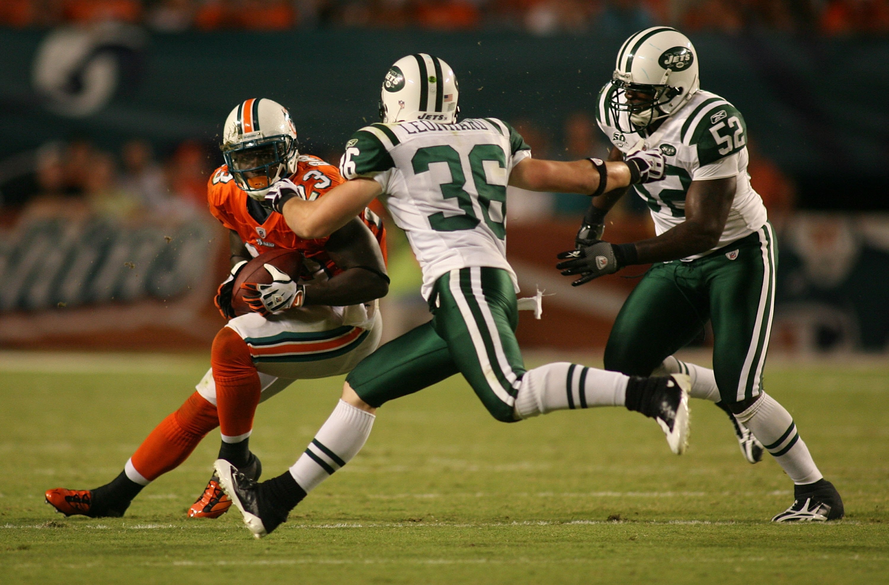 MIAMI - OCTOBER 12: Running back Ronnie Brown #23 of the Miami Dolphins runs against safety Jim Leonard #36 and linebacker David Harris #52 of the New York Jets at Land Shark Stadium on October 12, 2009 in Miami, Florida. Miami defeated New York 31-27. MIAMI - OCTOBER 12: Running back Ronnie Brown #23 of the Miami Dolphins runs against safety Jim Leonard #36 and linebacker David Harris #52 of the New York Jets at Land Shark Stadium on October 12, 2009 in Miami, Florida. Miami defeated New York 31-27.