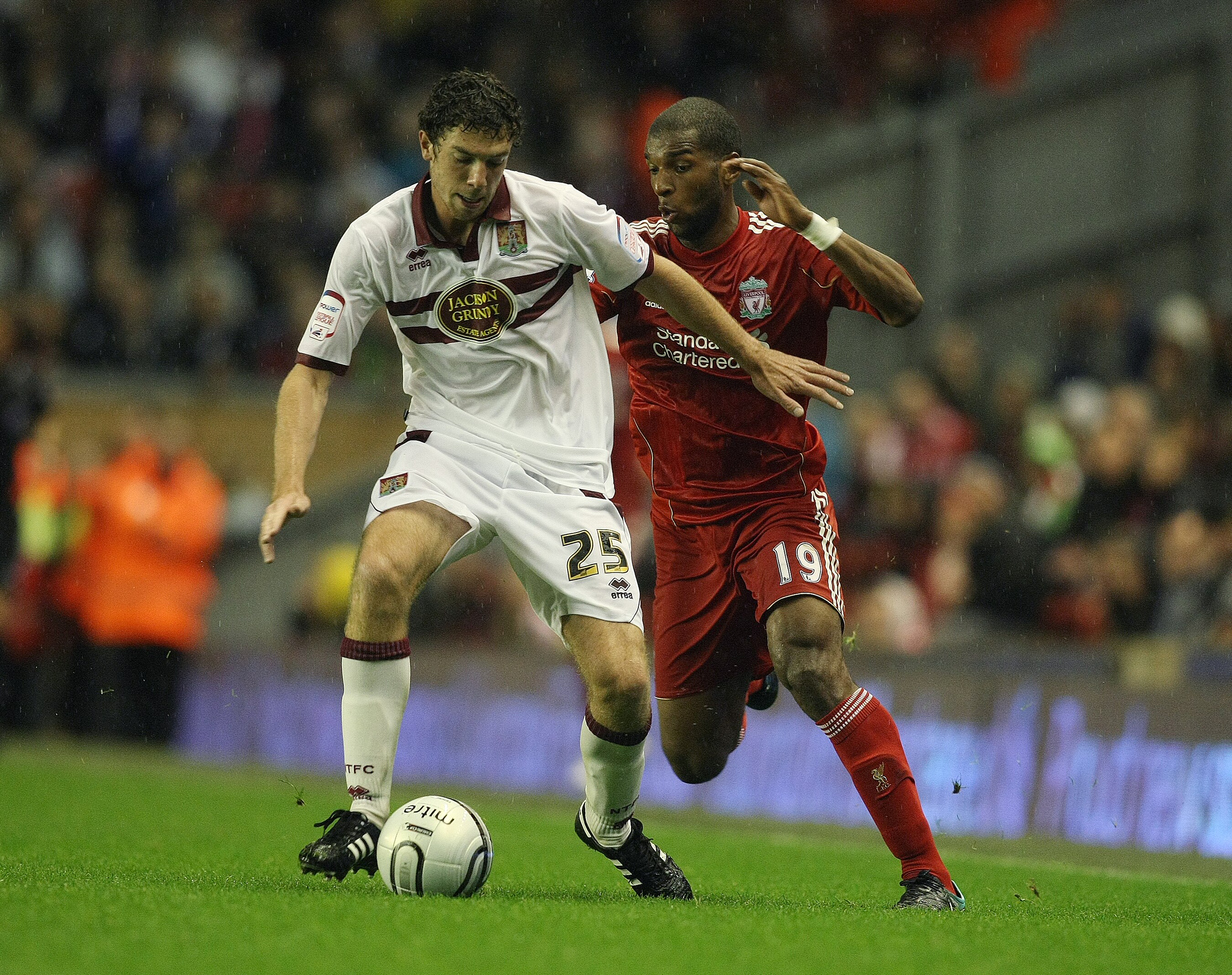 LIVERPOOL, ENGLAND - SEPTEMBER 22:  Ben Tozer of Northampton Town looks to play the ball under pressure from Ryan Babel of Liverpool during the Carling Cup Third Round match between Liverpool and Northampton Town at Anfield on September 22, 2010 in Liverp