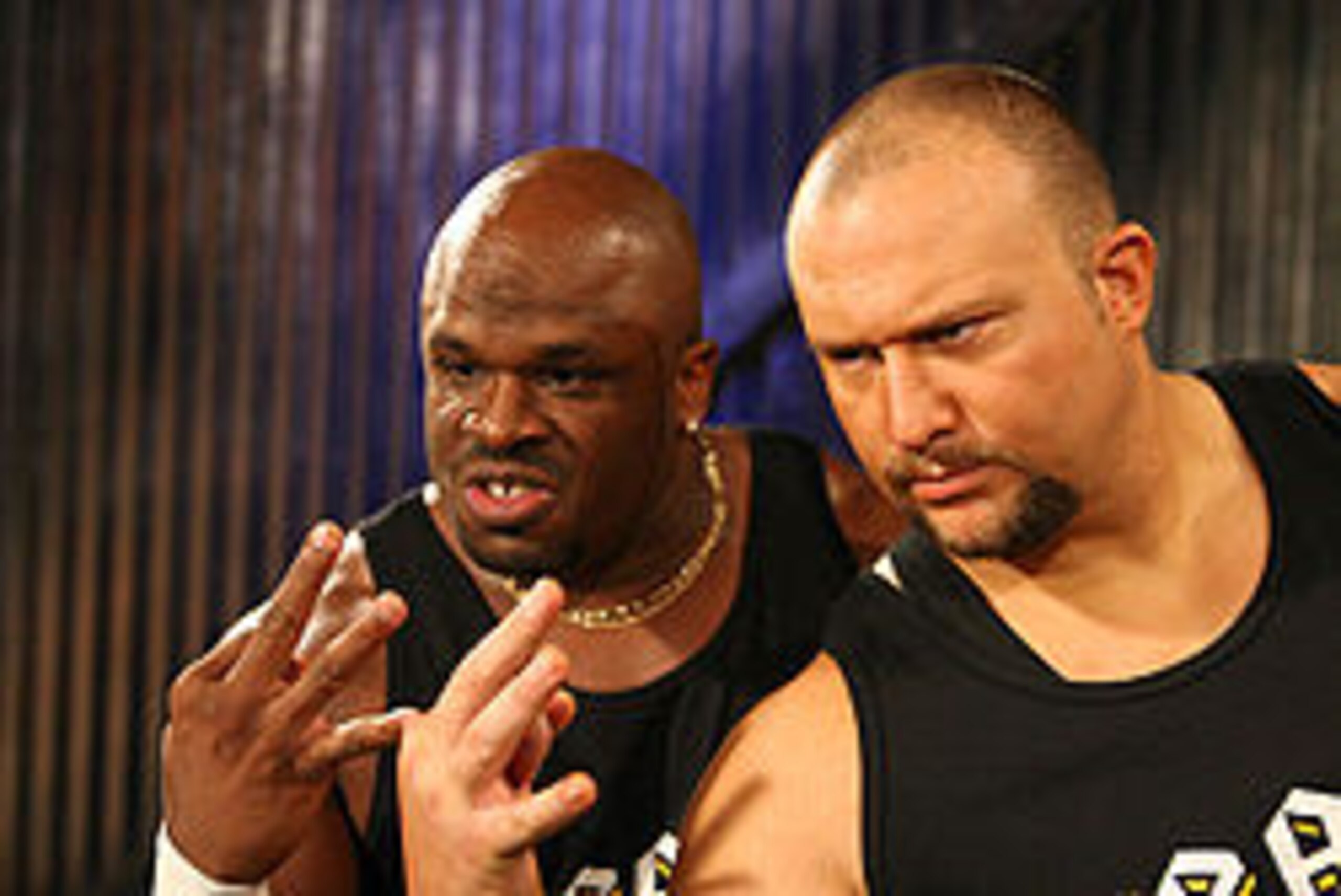 Brother Devon and Brother Ray making the 3D taunt (index finger and thumb forming the lower part of a 'd', the middle finger forming the upper part of the 'd' while also representing the number 3 along with the two remaining digits)