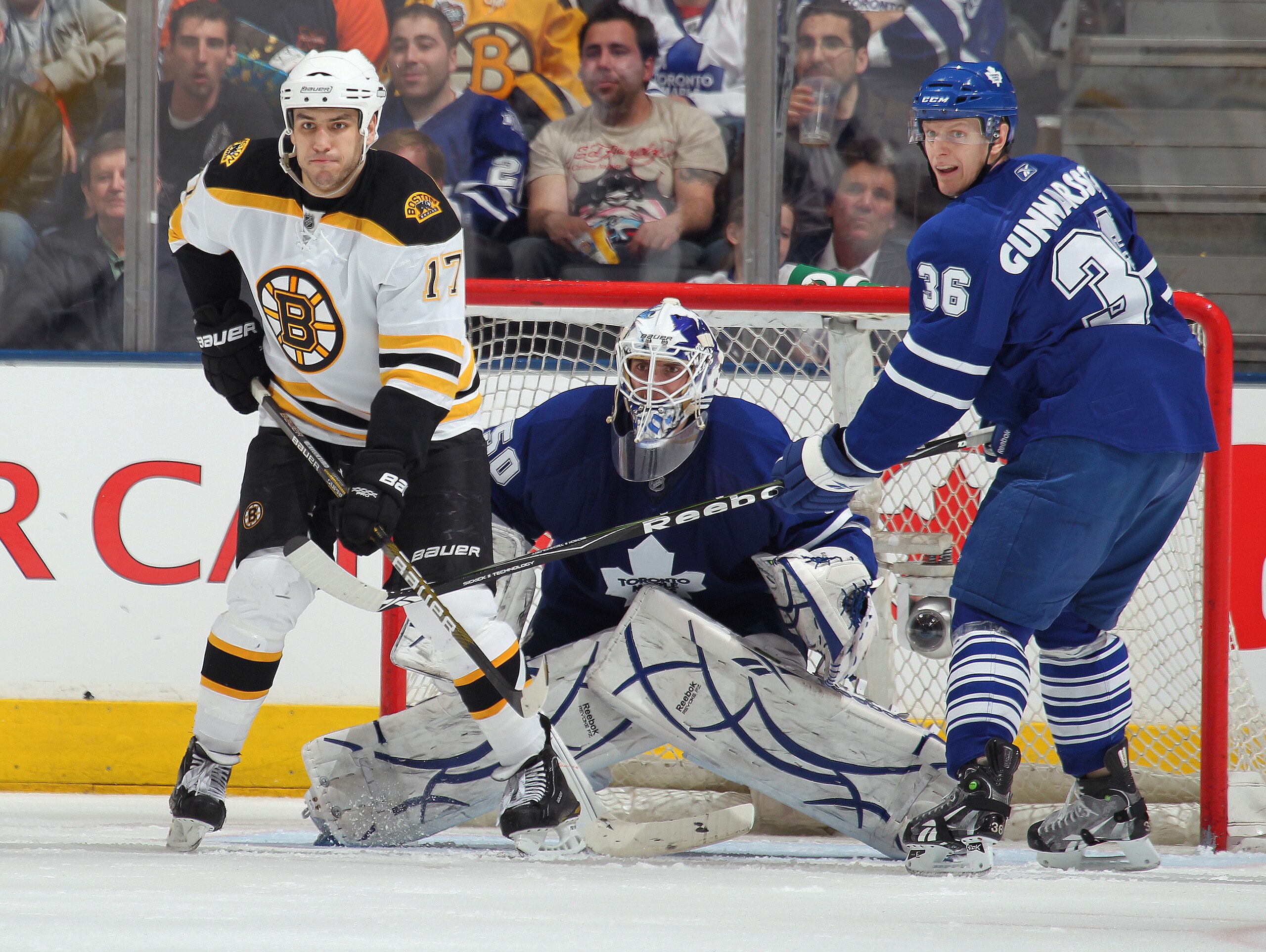 TORONTO, ON - APRIL 3: Milan Lucic #17 of the Boston Bruins waits to deflect a shot next to Jonas Gustavsson #50 and Carl Gunnarsson #36 of the Toronto Maple Leafs in a game on April 3, 2010 at the Air Canada Centre in Toronto, Ontario. (Photo by Claus An