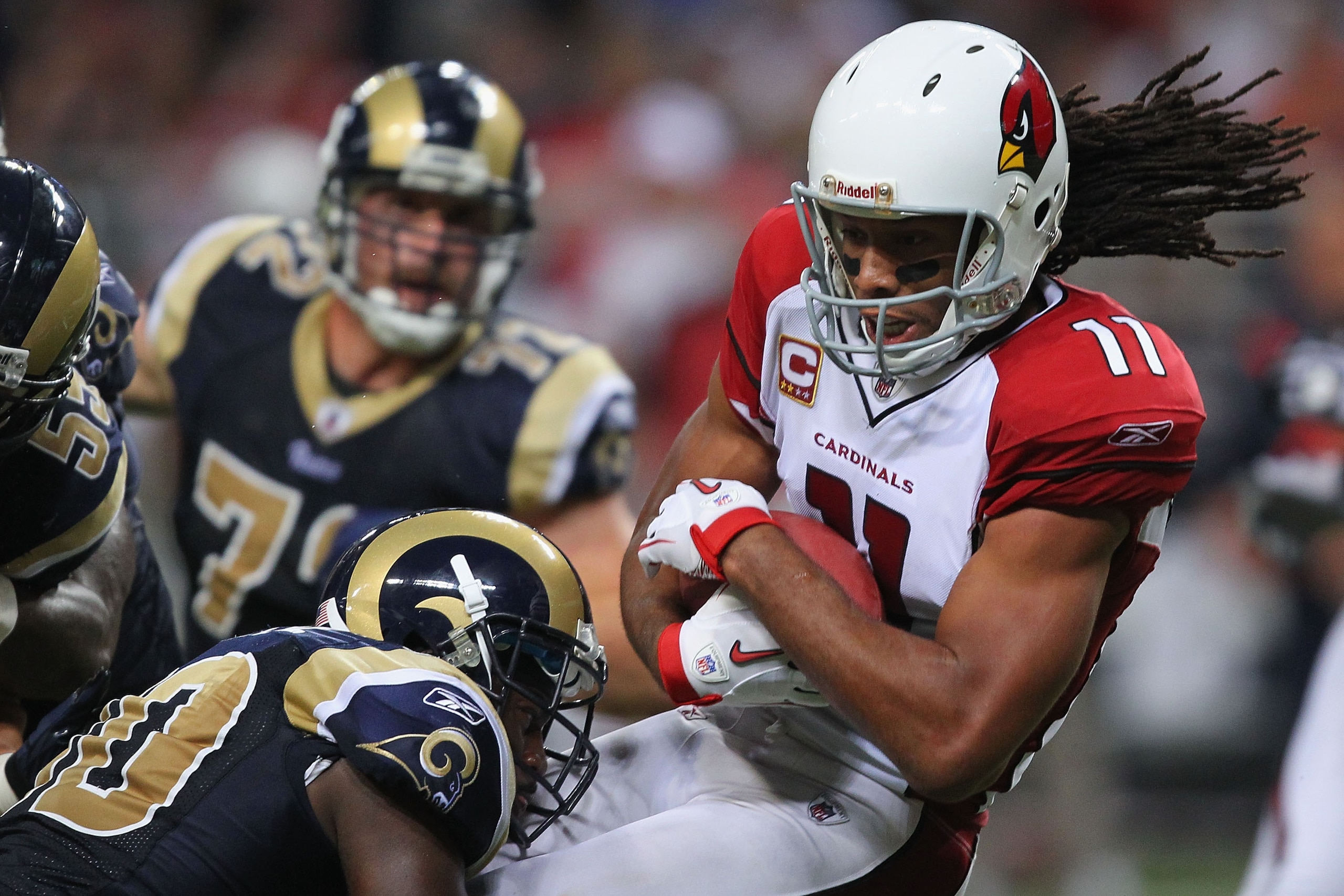ST. LOUIS - SEPTEMBER 12: Larry Fitzgerald #11 of the Arizona Cardinals makes a catch against the St. Louis Rams during the NFL season opener at the Edward Jones Dome on September 12, 2010 in St. Louis, Missouri.  The Cardinals beat the Rams 17-13.  (Phot