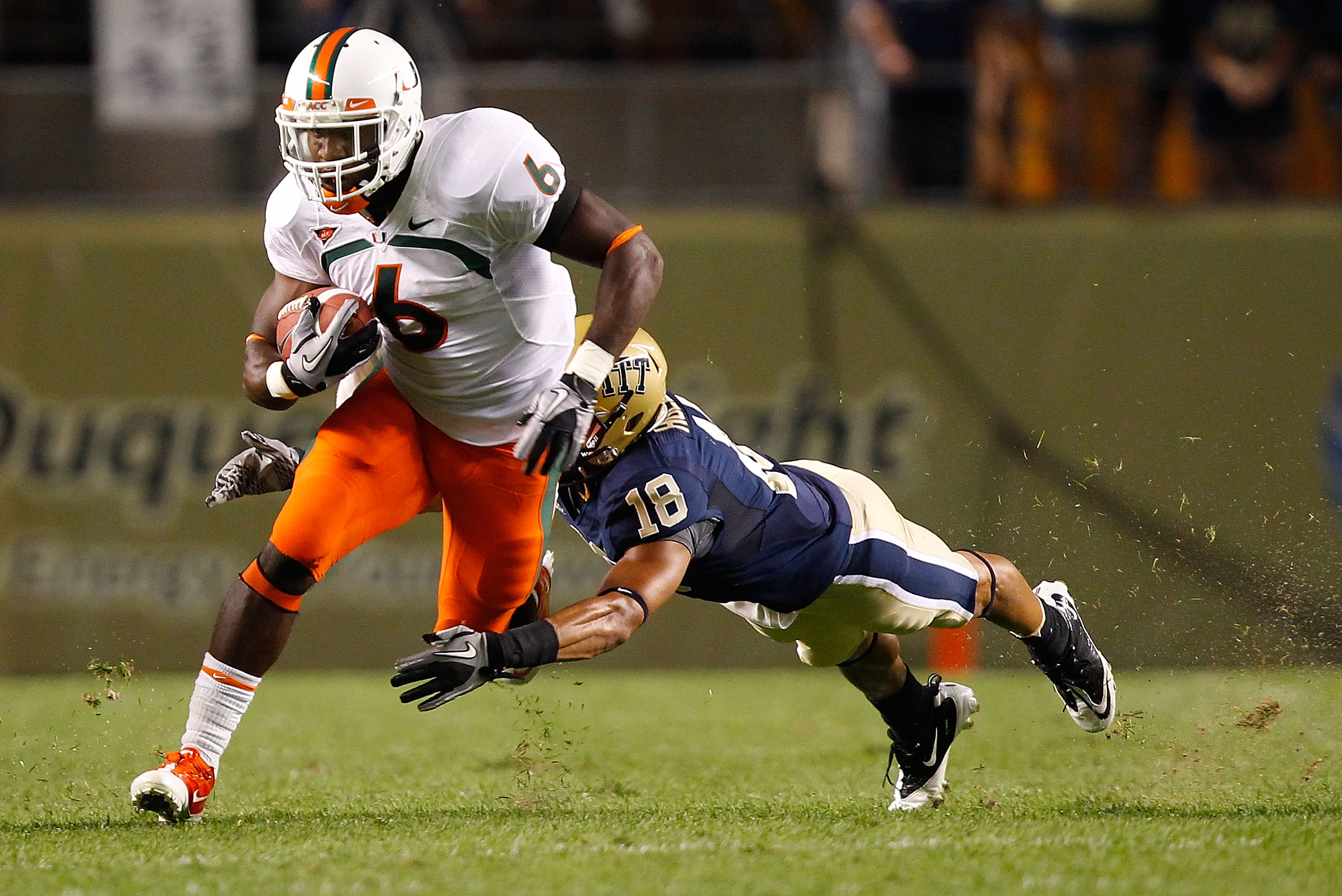 PITTSBURGH - SEPTEMBER 23:  Lamar Miller #6 of the Miami Hurricanes runs through an attempted tackle by Jarred Holley #18 of the Pittsburgh Panthers on September 23, 2010 at Heinz Field in Pittsburgh, Pennsylvania.  (Photo by Jared Wickerham/Getty Images)